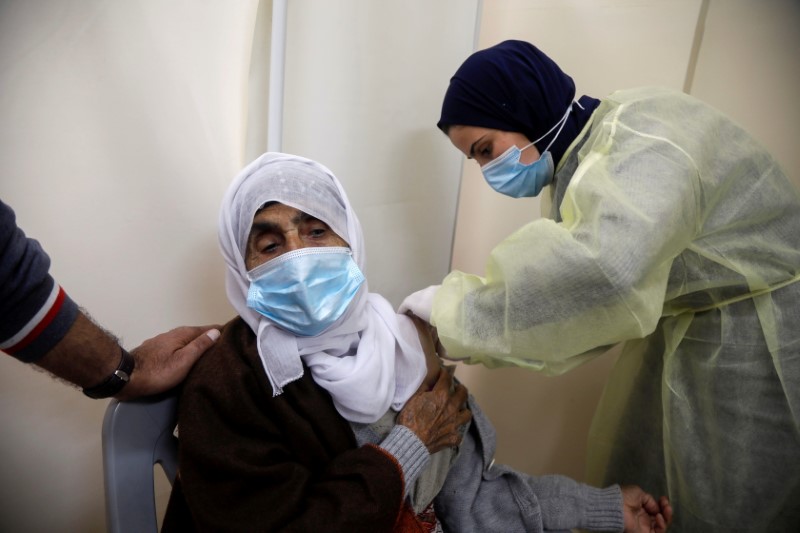 A Palestinian health worker gives a woman a dose of AstraZeneca vaccine against the coronavirus disease (COVID-19) during a vaccination drive in Tubas, in the Israeli-occupied West Bank