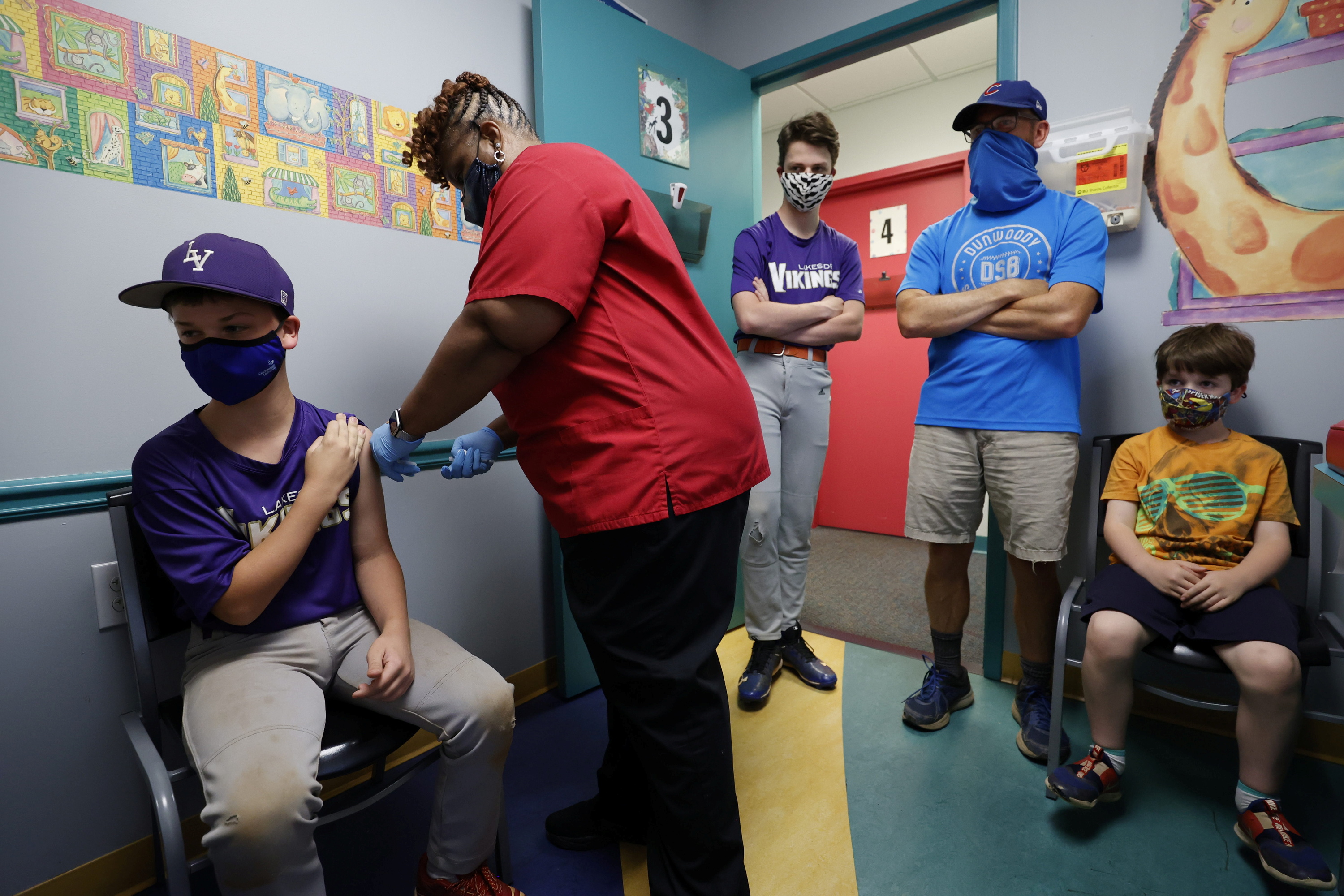 Family members look on as Jack Frilingos, 12, is inoculated with Pfizer's vaccine against coronavirus disease (COVID-19) after Georgia authorized the vaccine for ages over 12 years, at Dekalb Pediatric Center in Decatur