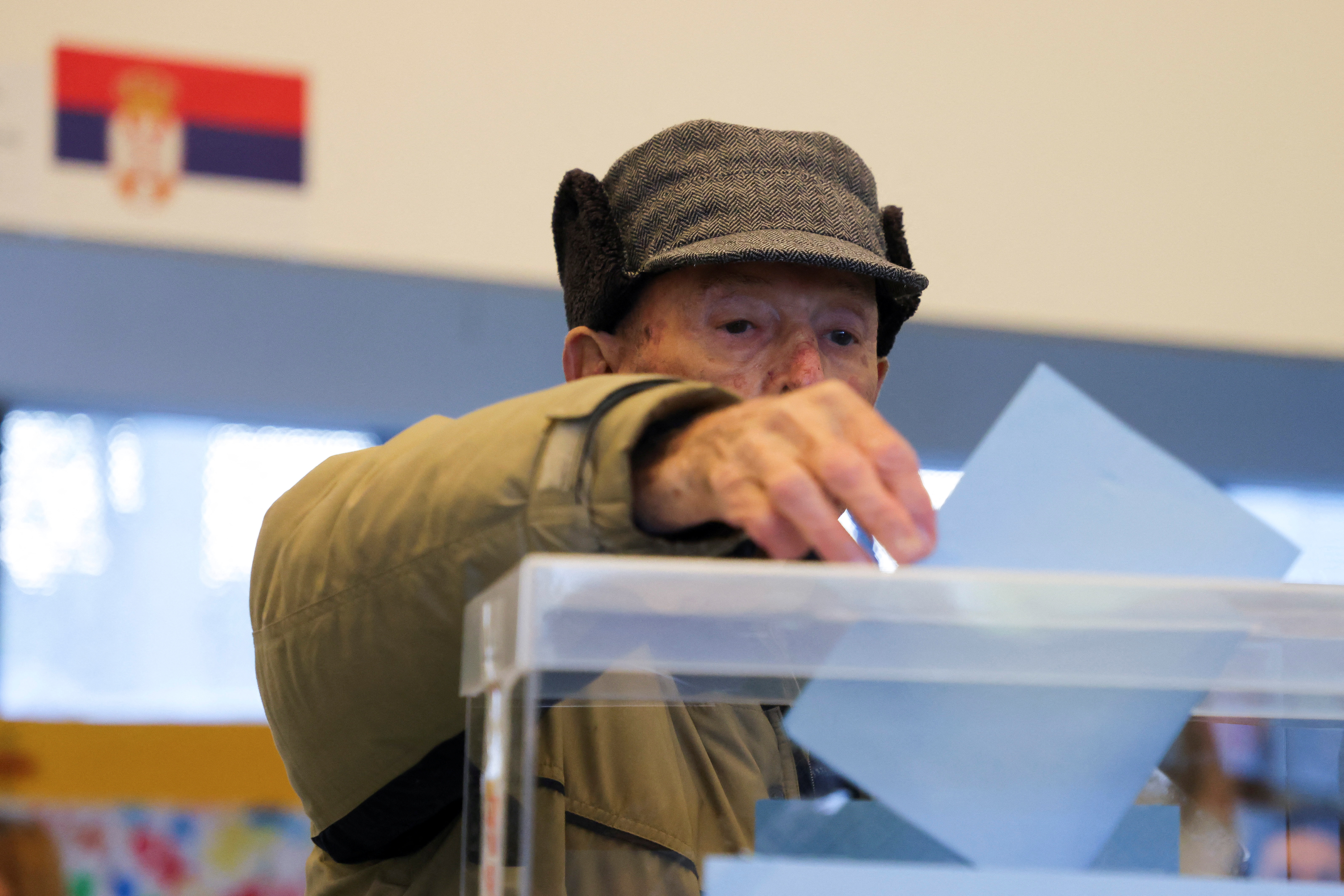 A man casts his vote at a polling station during the general election, in Belgrade