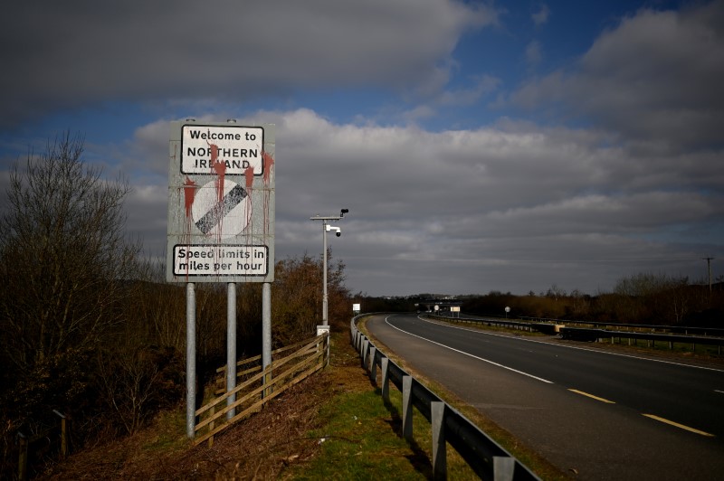 A defaced 'Welcome to Northern Ireland' sign is seen on the Ireland and Northern Ireland border reminding motorists that the speed limits will change from kilometres per hour to miles per hour on the border in Carrickcarnan, Ireland, March 6, 2021. REUTERS/Clodagh Kilcoyne