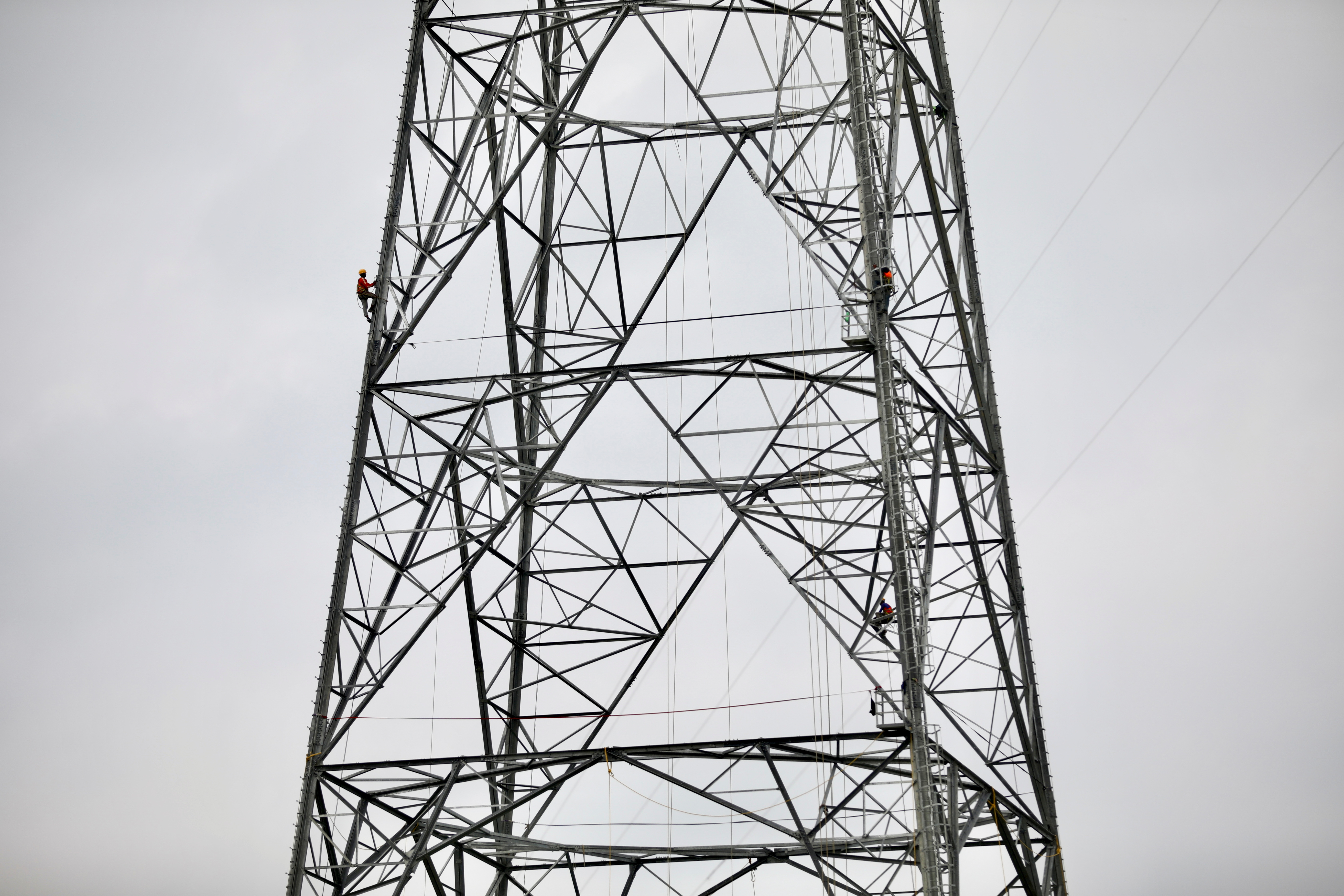 A worker climbs an under construction power transmission tower in Munshiganj
