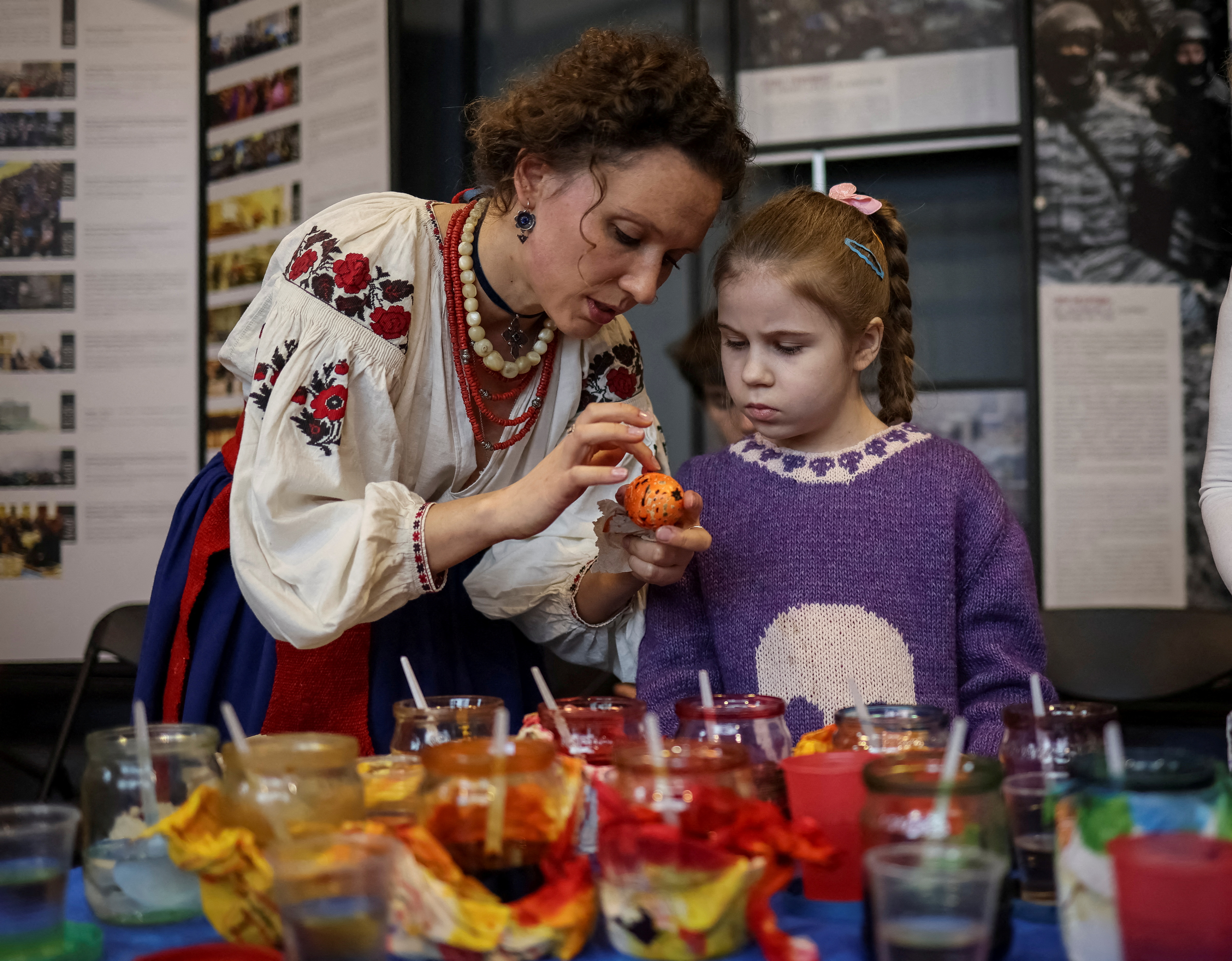 Una niña mira un huevo de Pascua pintado al estilo tradicional en Kiev