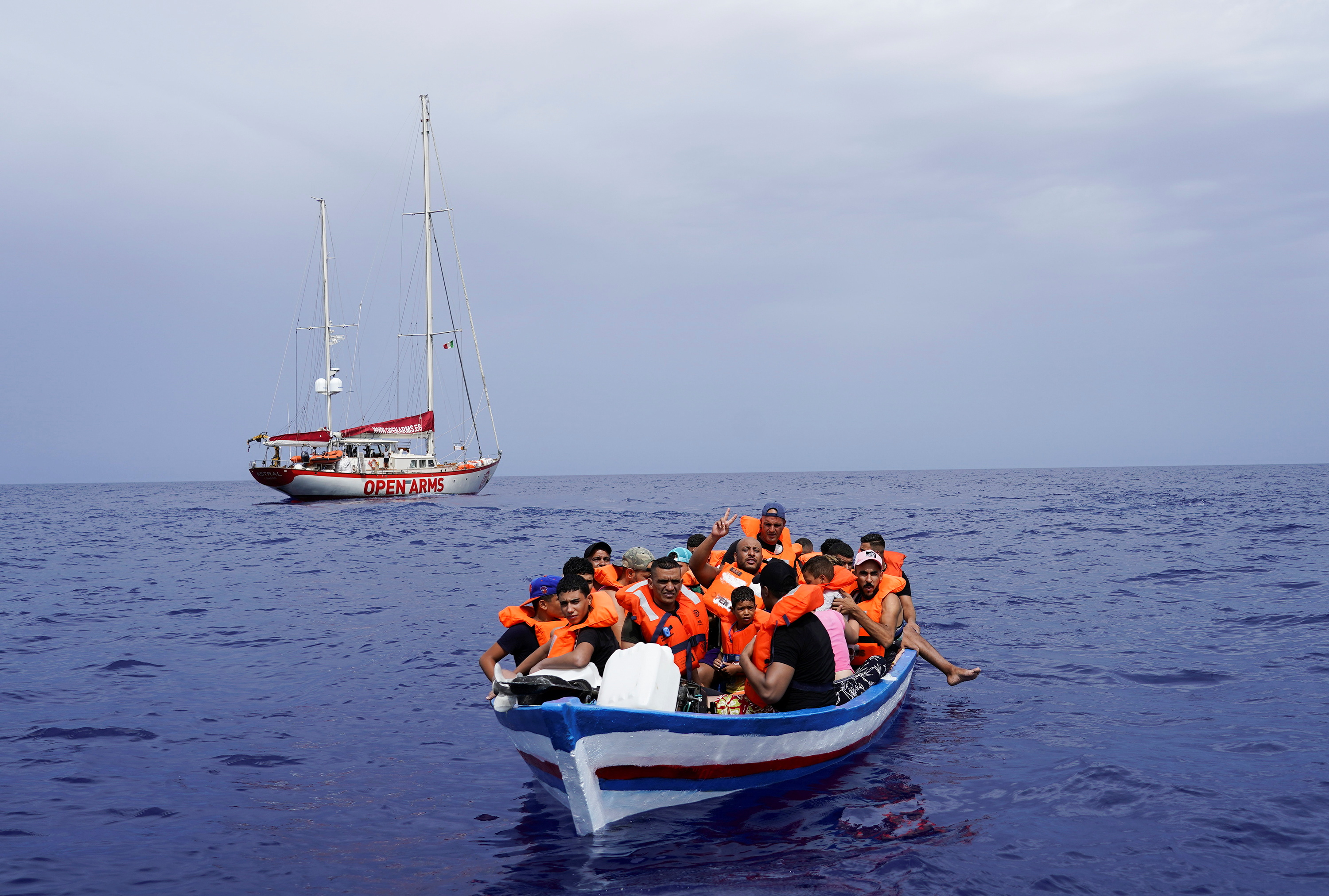 Migrants on a wooden boat wait for the Italian Guardia Costiera near the island of Lampedusa, in the Mediterranean Sea, September 1, 2021. REUTERS/Juan Medina