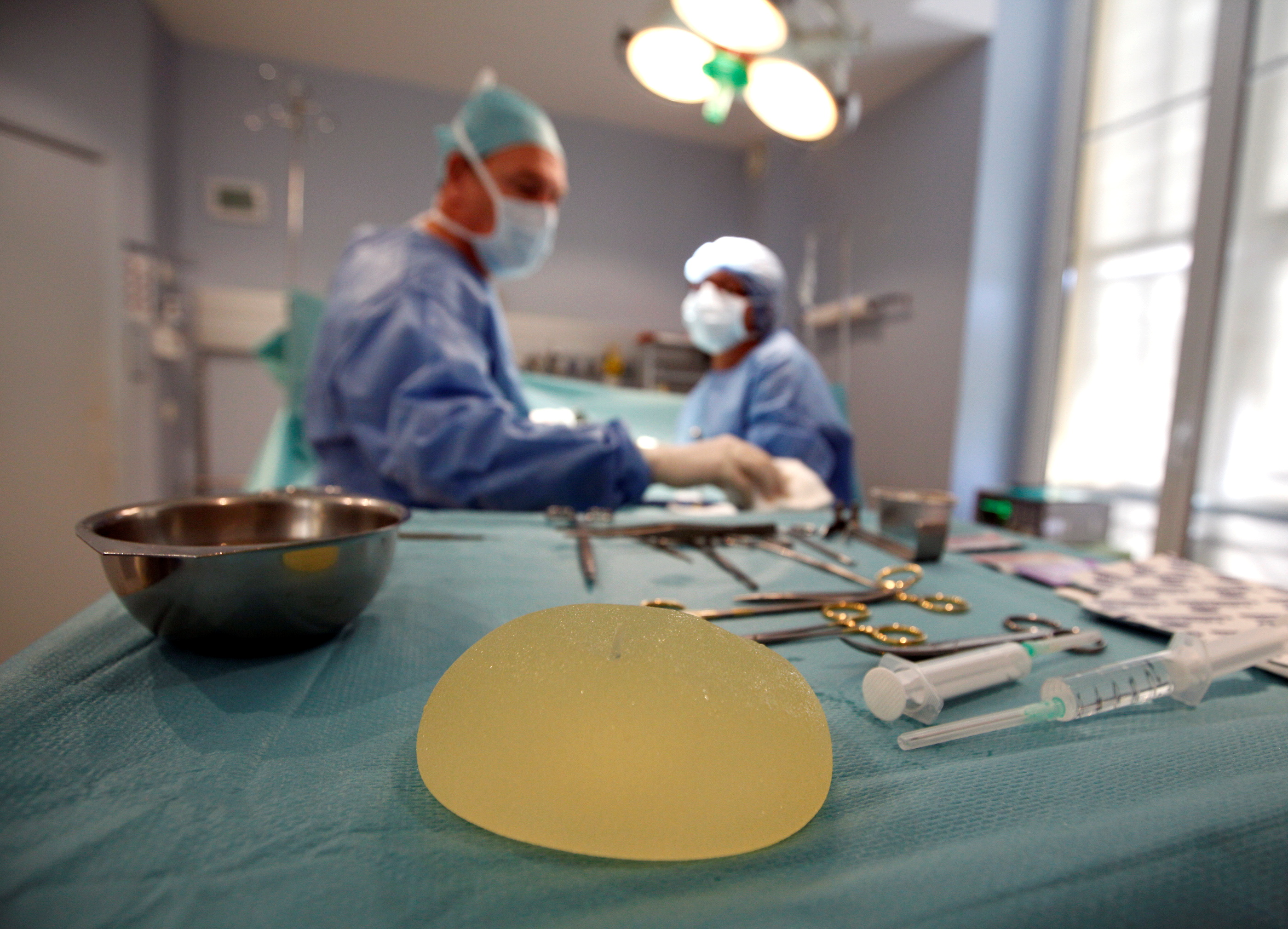 A defective silicone gel breast implant manufactured by French company Poly Implant Prothese (PIP) is seen near surgical instruments after being removed from a patient by plastic surgeon Denis Boucq (L) in a clinic in Nice December 21, 2011.  REUTERS/Eric Gaillard