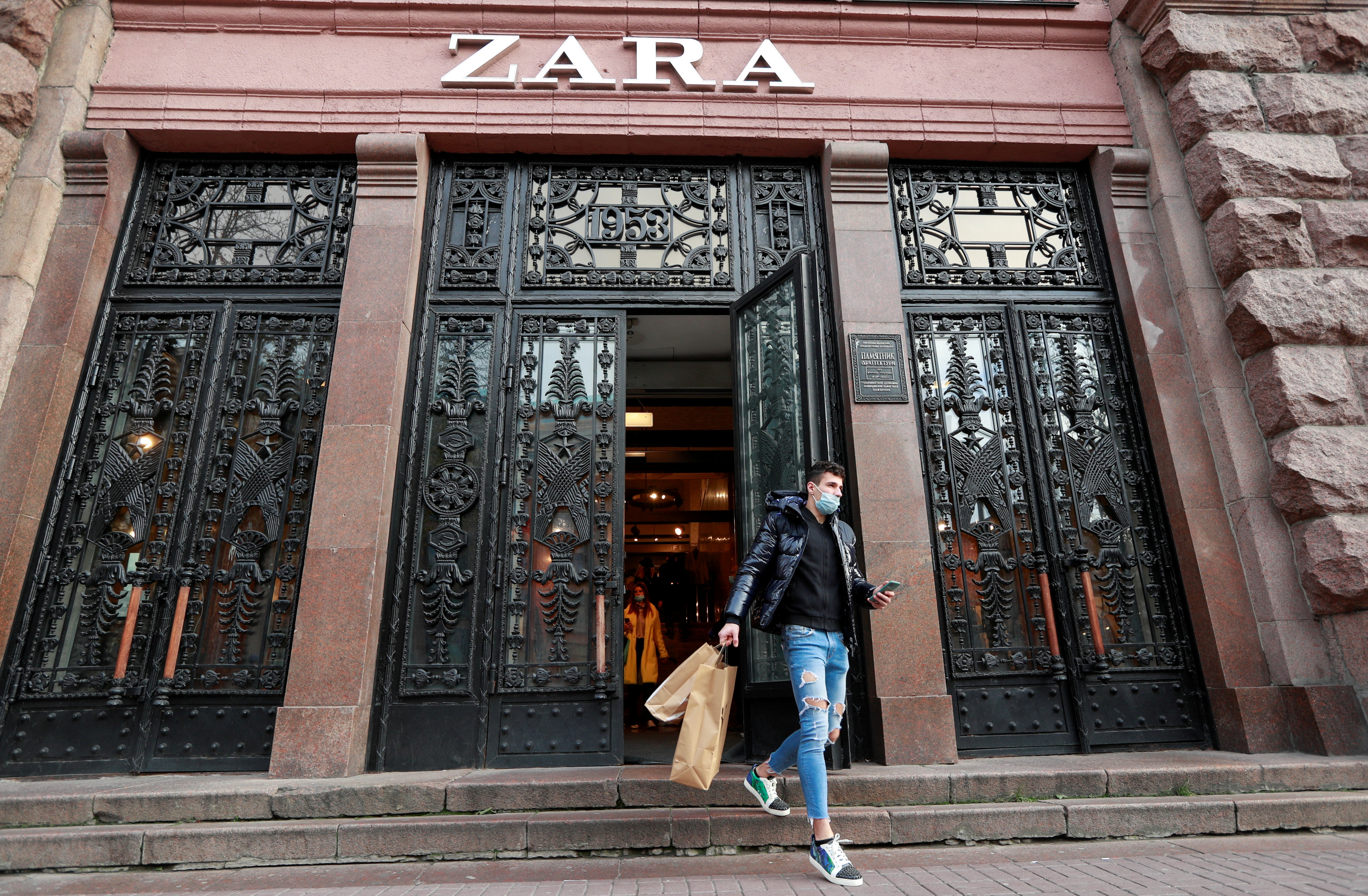 A man wearing a protective mask walks out of a Zara store in central Kyiv