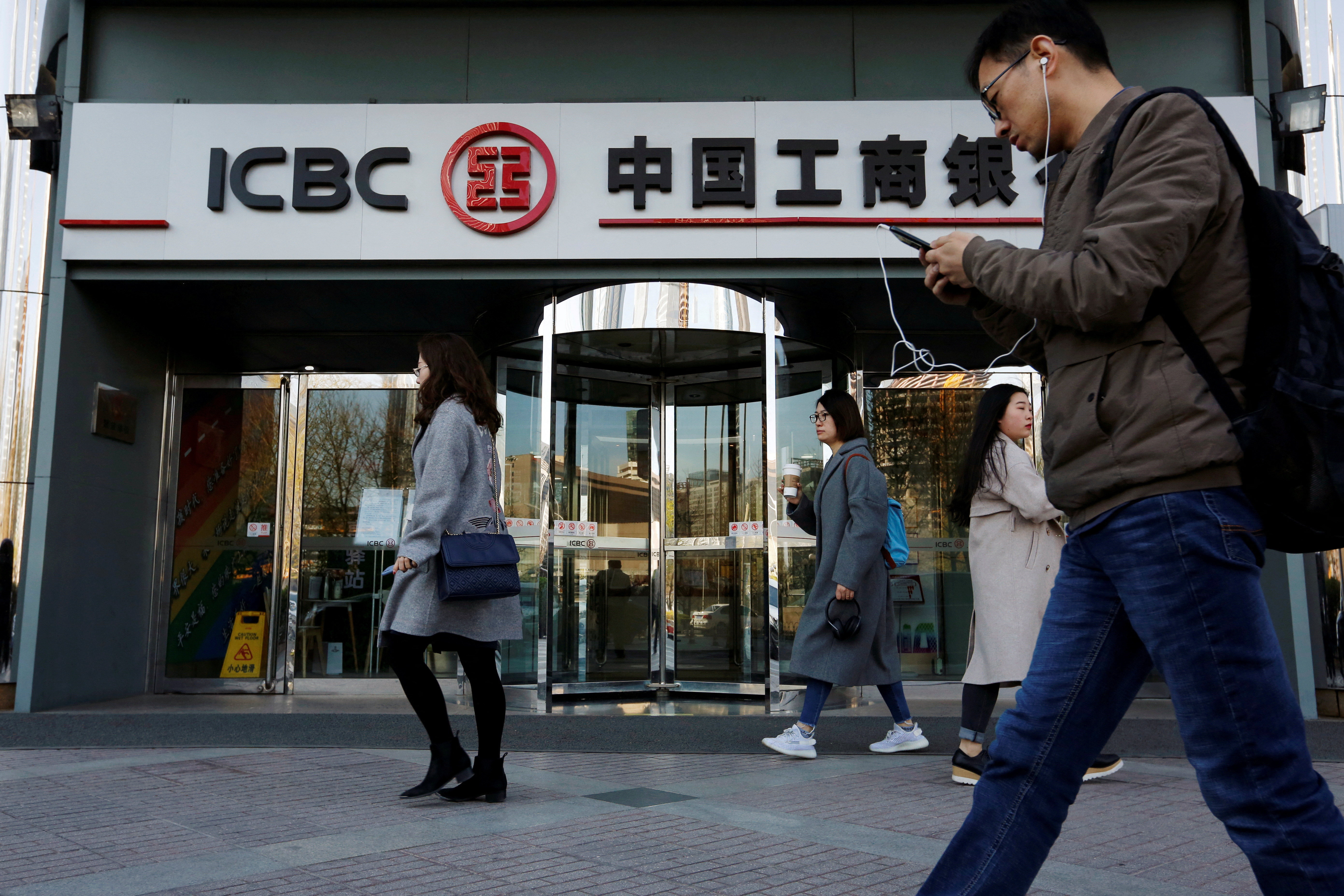 People walk past a branch of Industrial and Commercial Bank of China (ICBC) in Beijing
