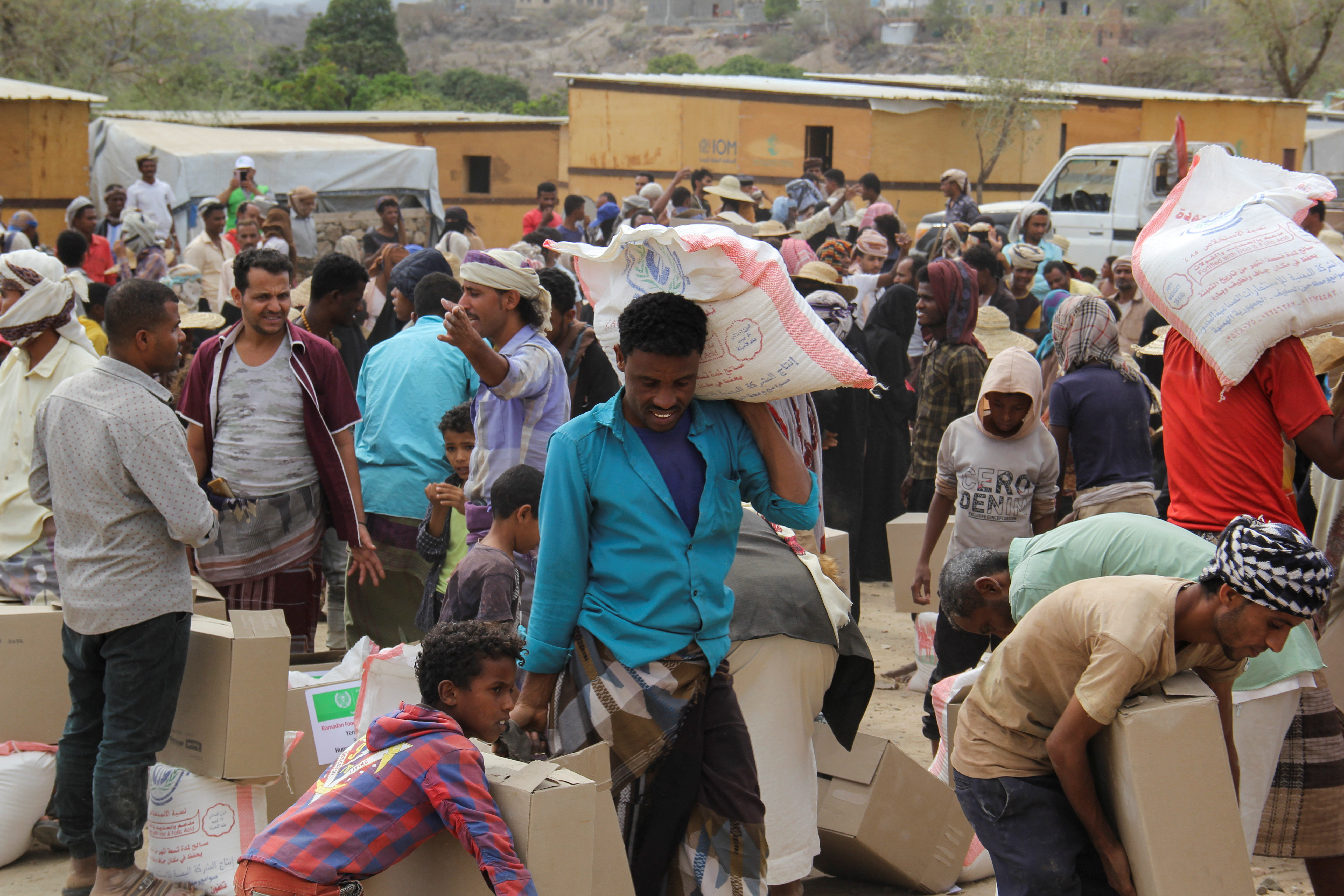 Internally displaced people collect food aid distributed by a charity in Taiz