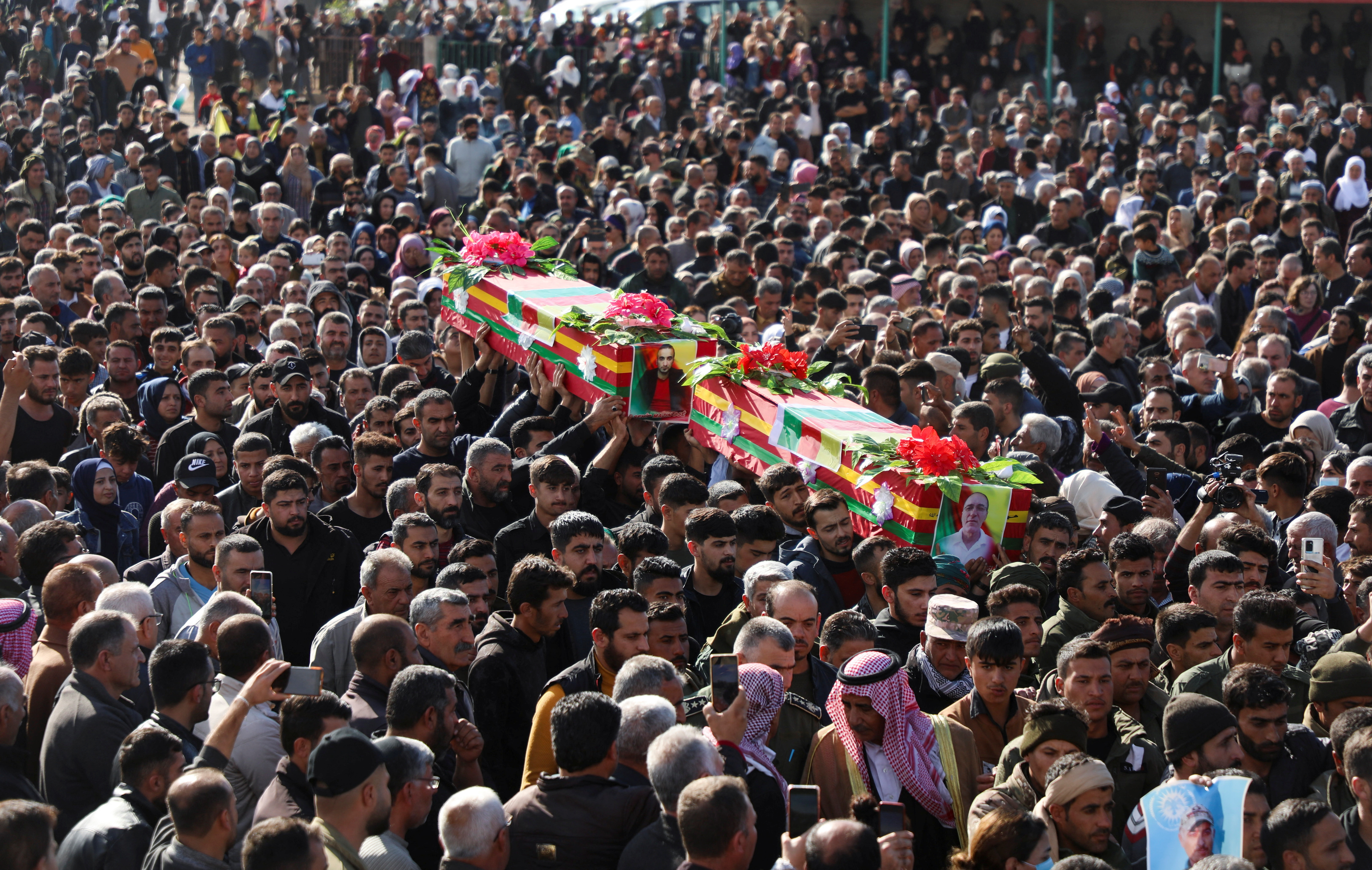 People carry coffins during a funeral in Derik countryside