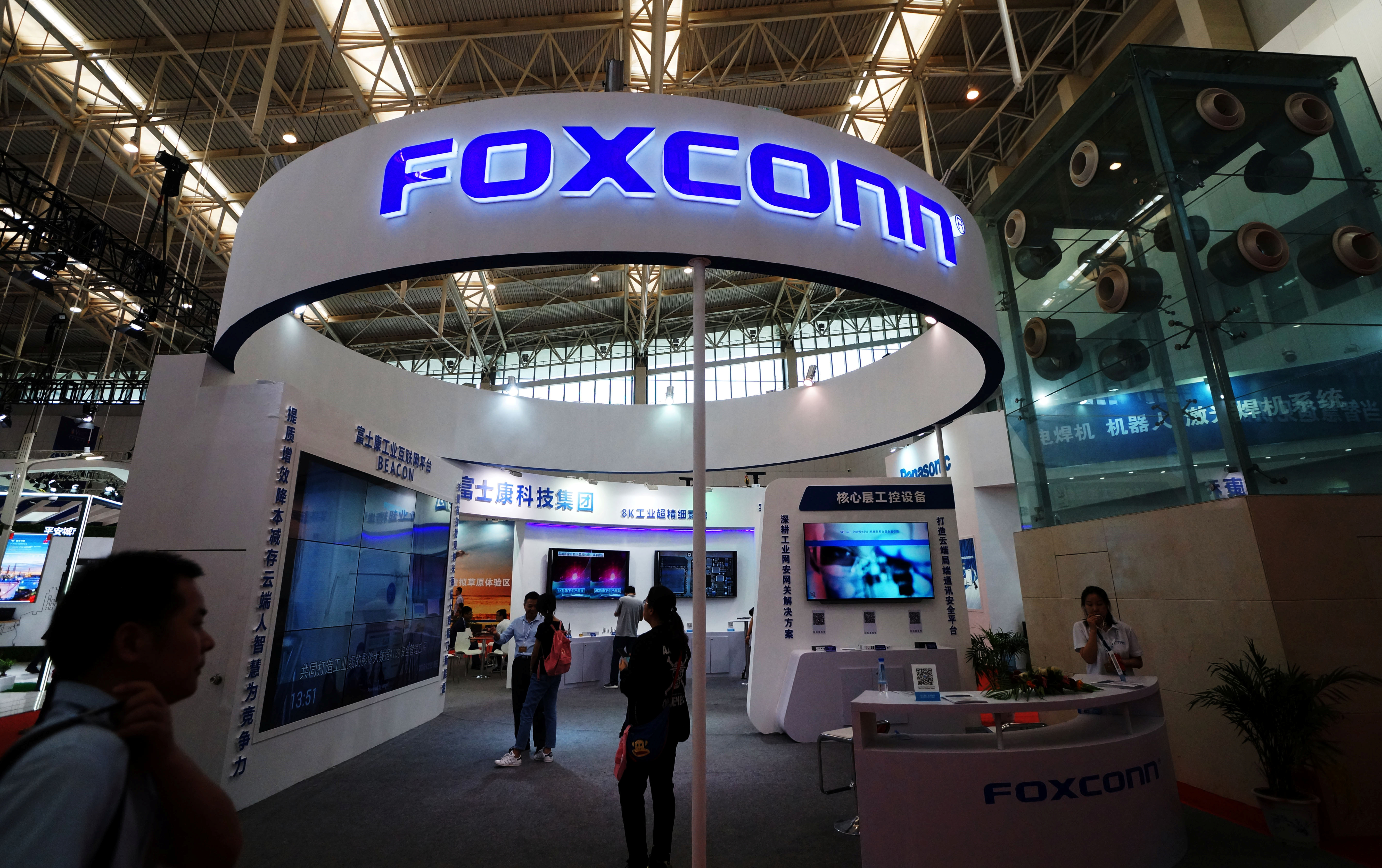 Visitors are seen at a Foxconn booth at the World Intelligence Congress in Tianjin