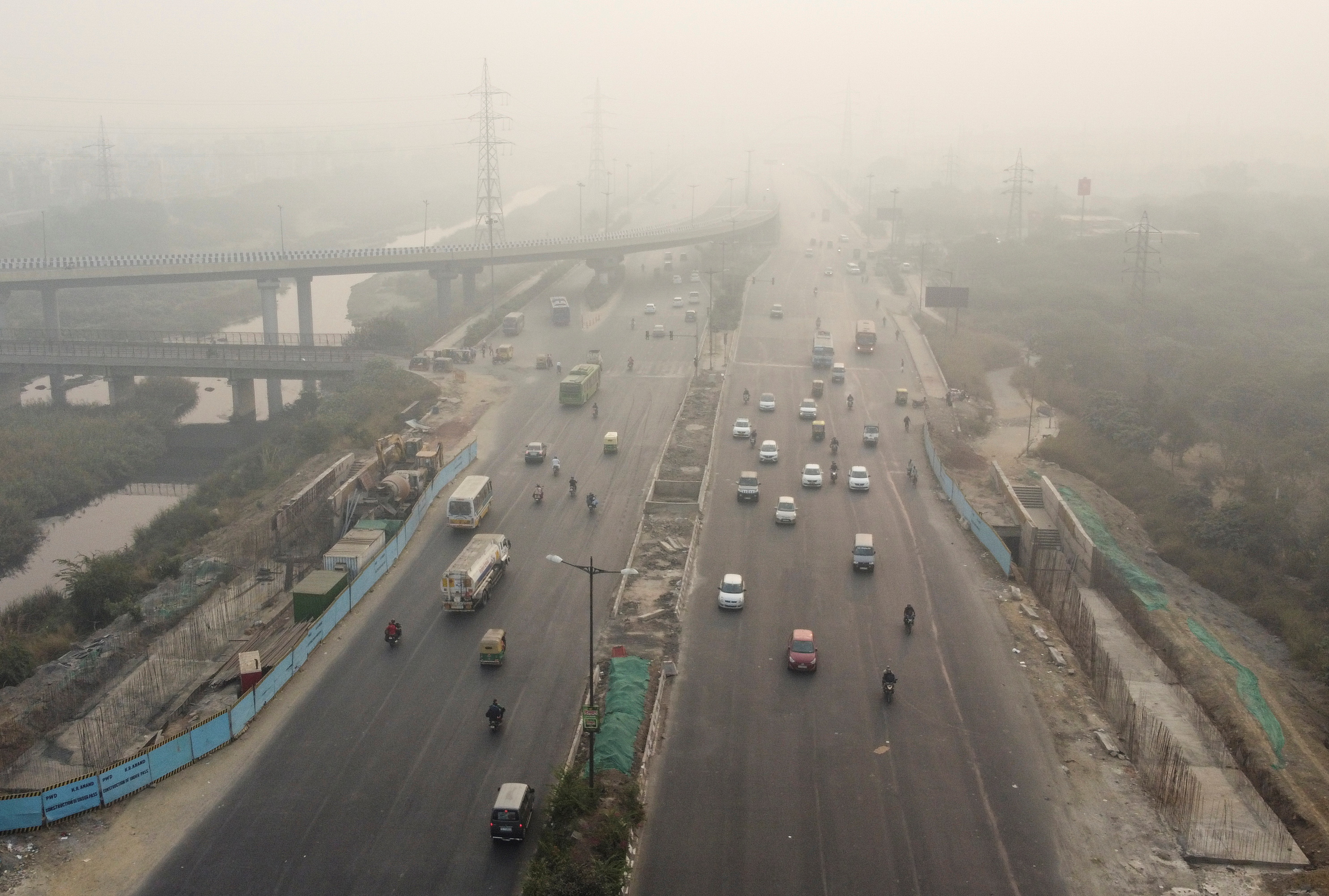 Traffic moves on a highway shrouded in smog in New Delhi