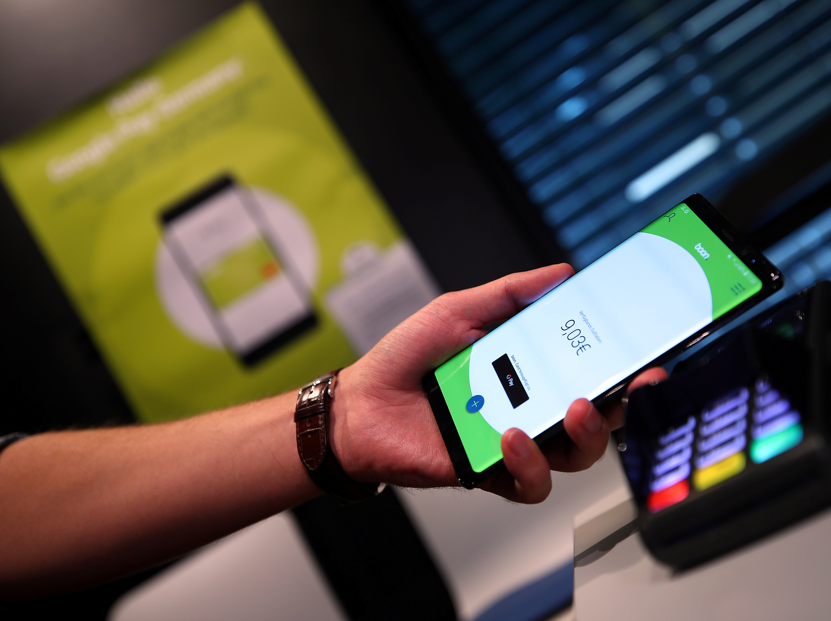 An employee of Wirecard AG, presents the contactless payment system 