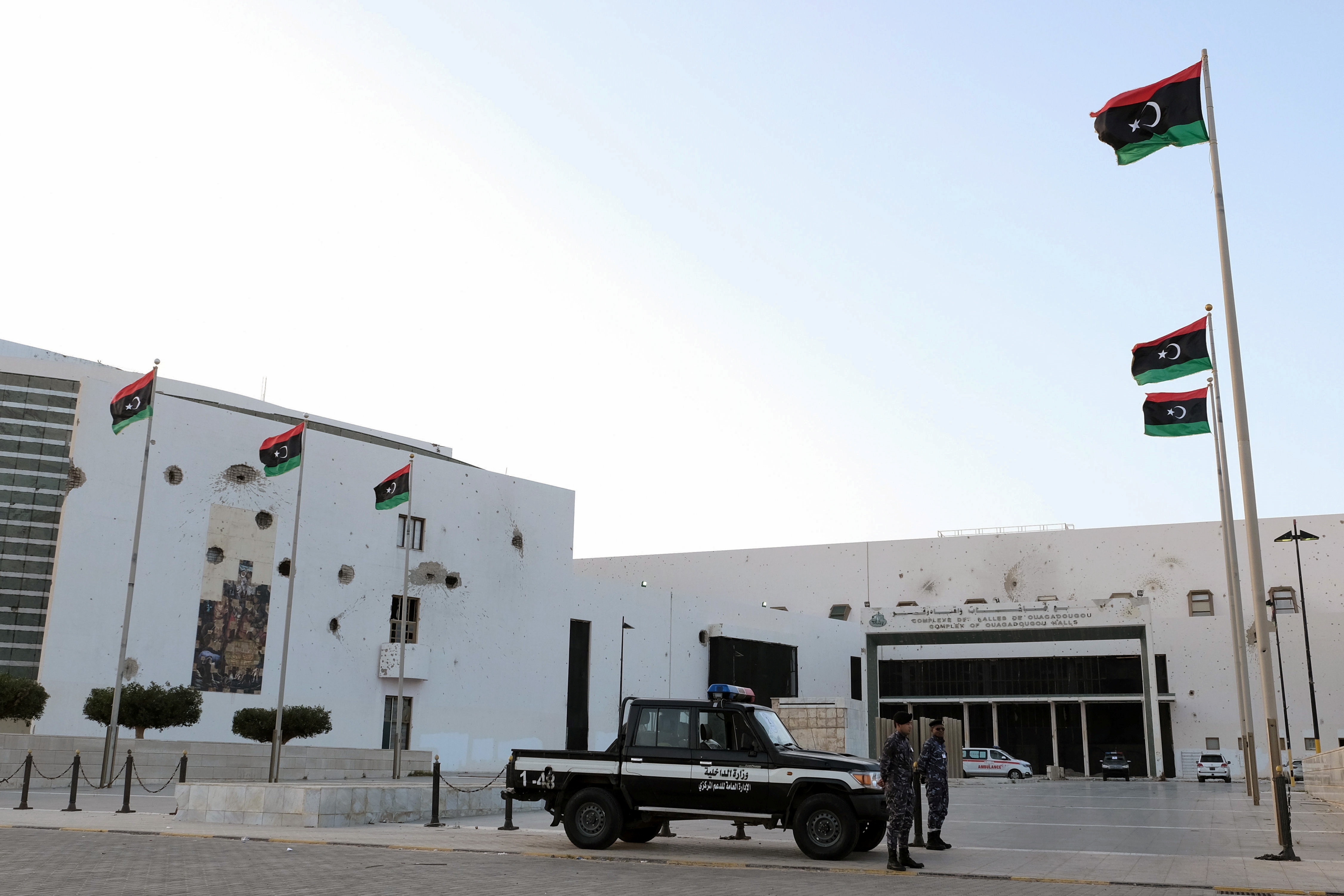 Security forces stand guard outside the Parliament building, in Sirte