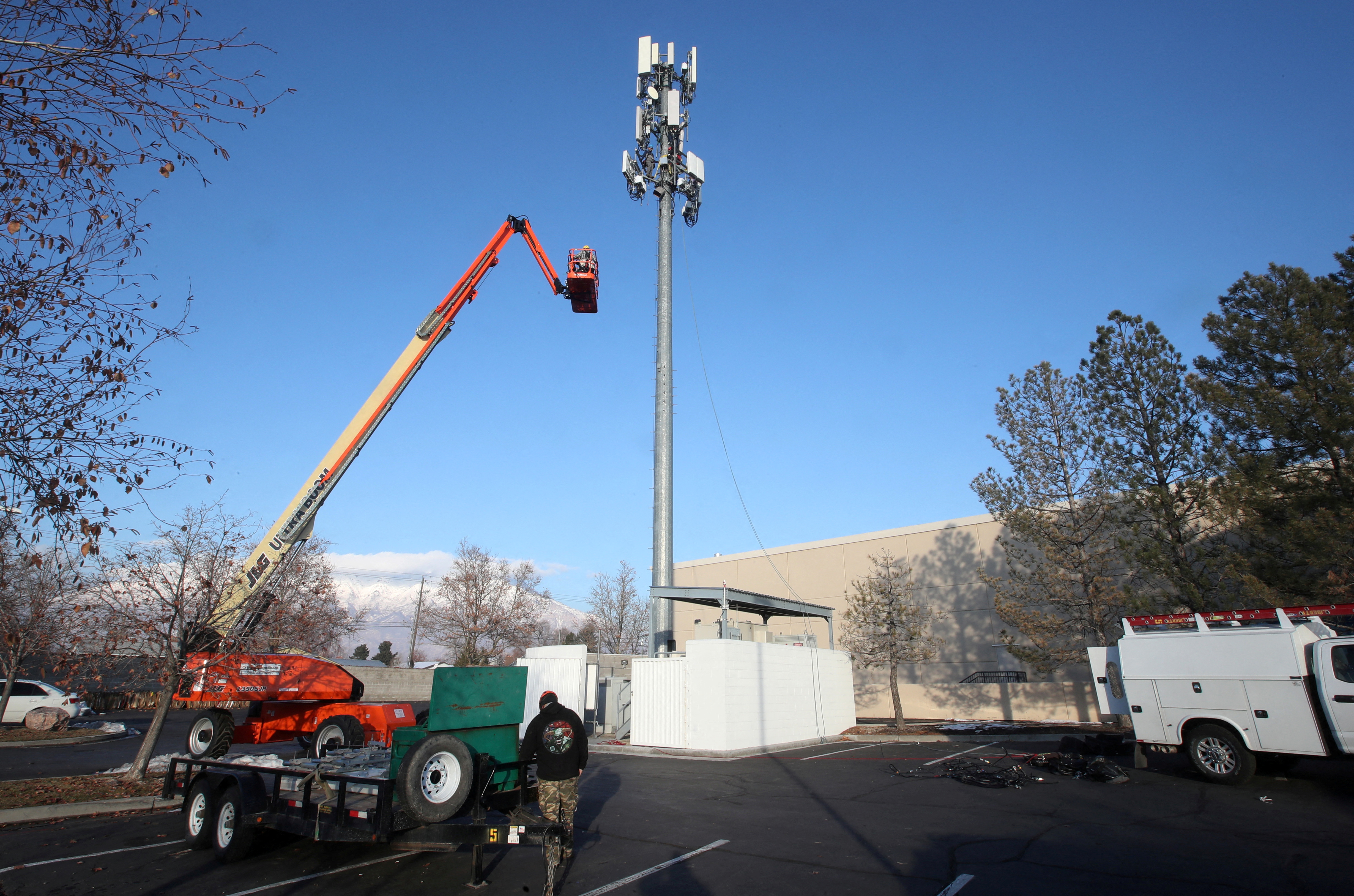 A contract crew from Verizon installs 5G equipment on a tower in Orem