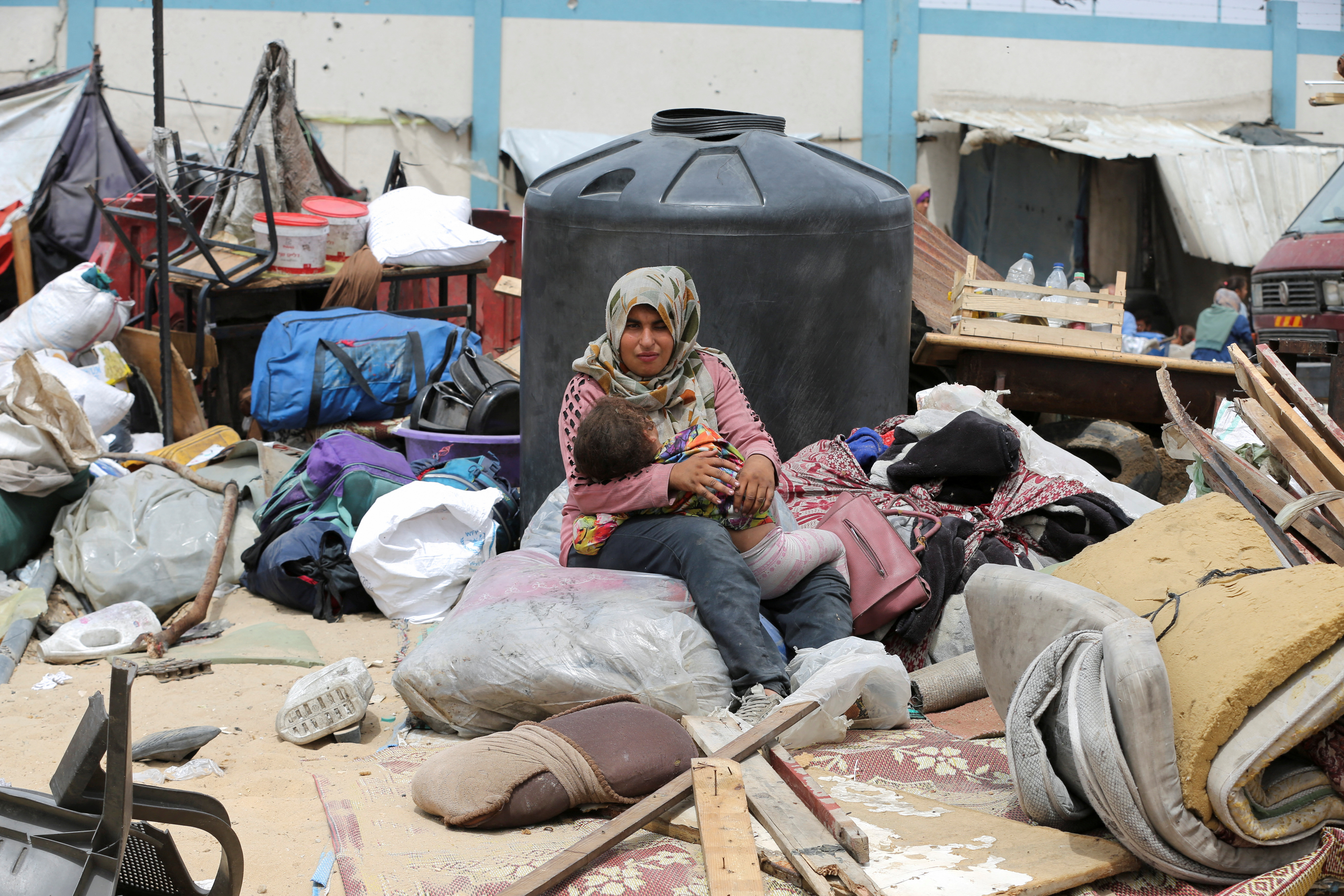 Palestinians travel on foot along with their belongings as they flee Rafah due to an Israeli military operation