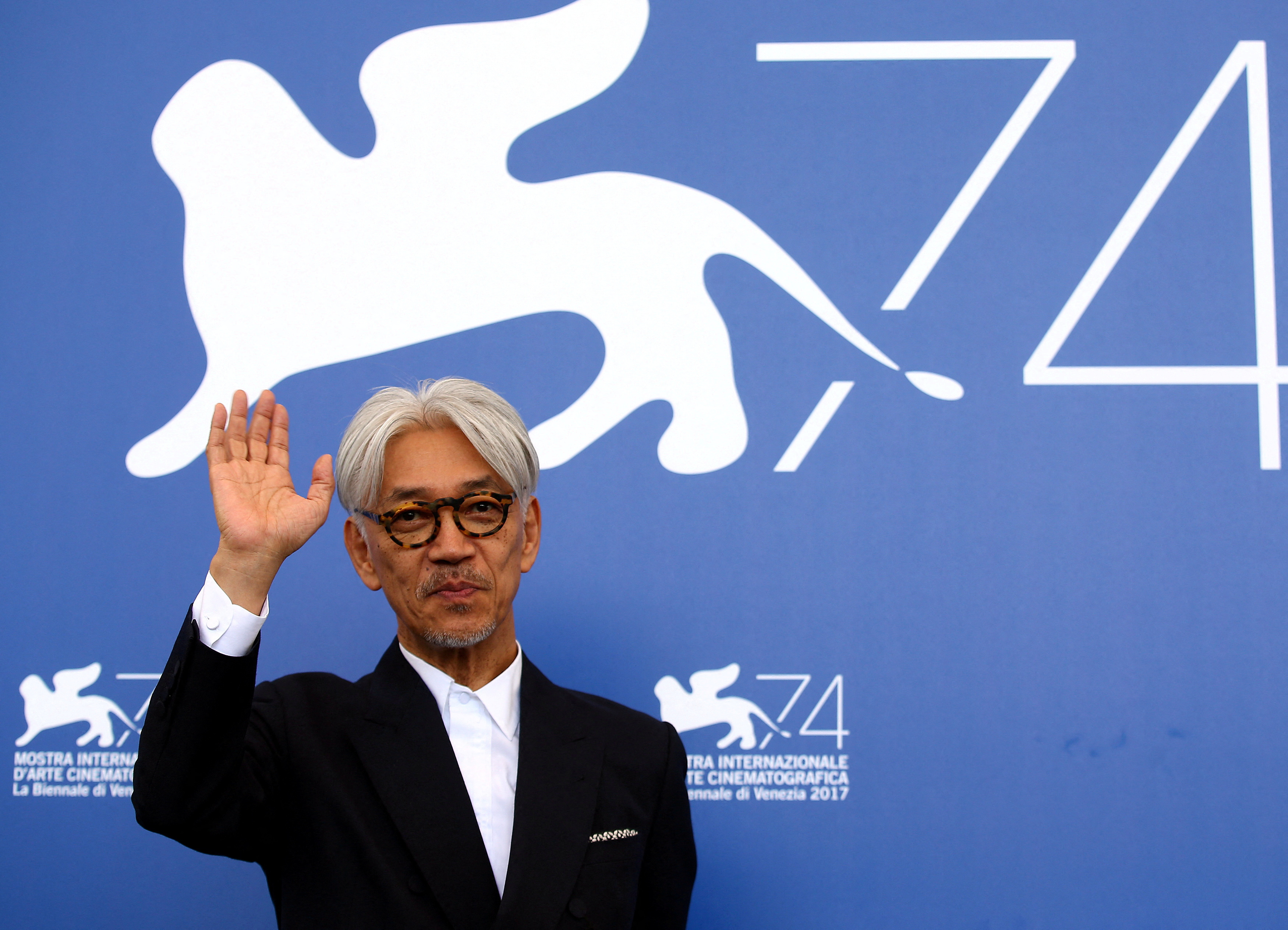 Japanese musician and composer Sakamoto waves during a photocall for the movie 