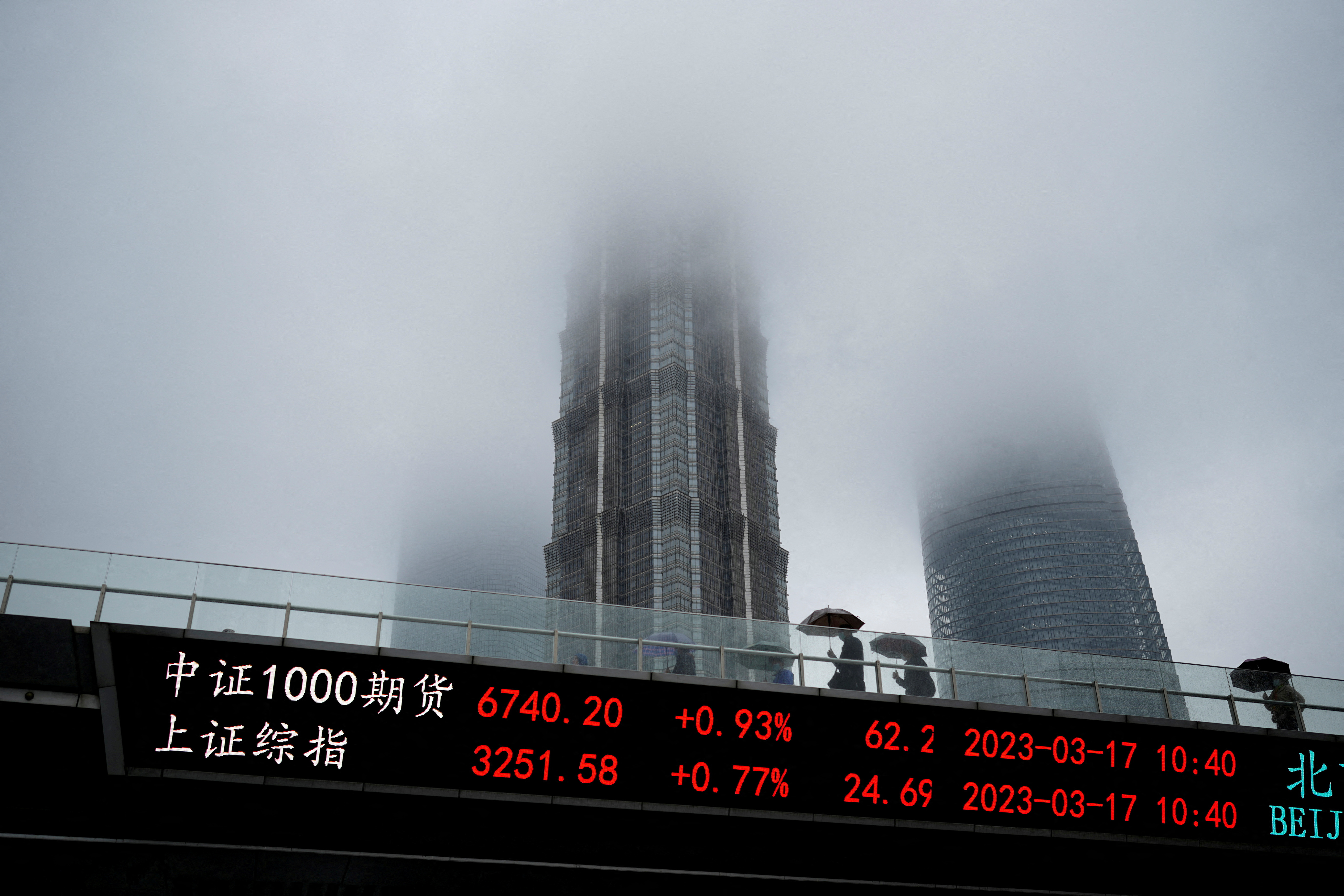 An electronic board shows stock indices at the Lujiazui financial district in Shanghai