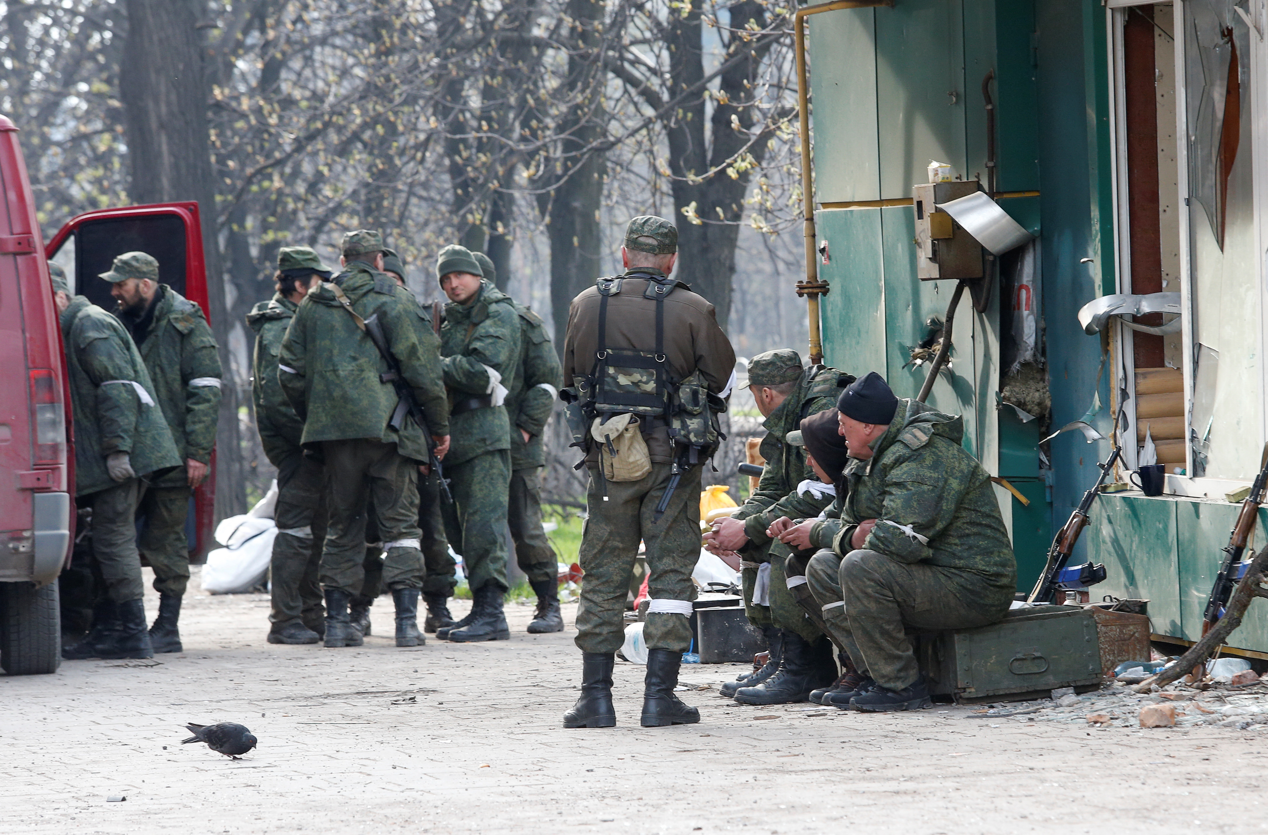 Service members of pro-Russian troops gather in a street in Mariupol