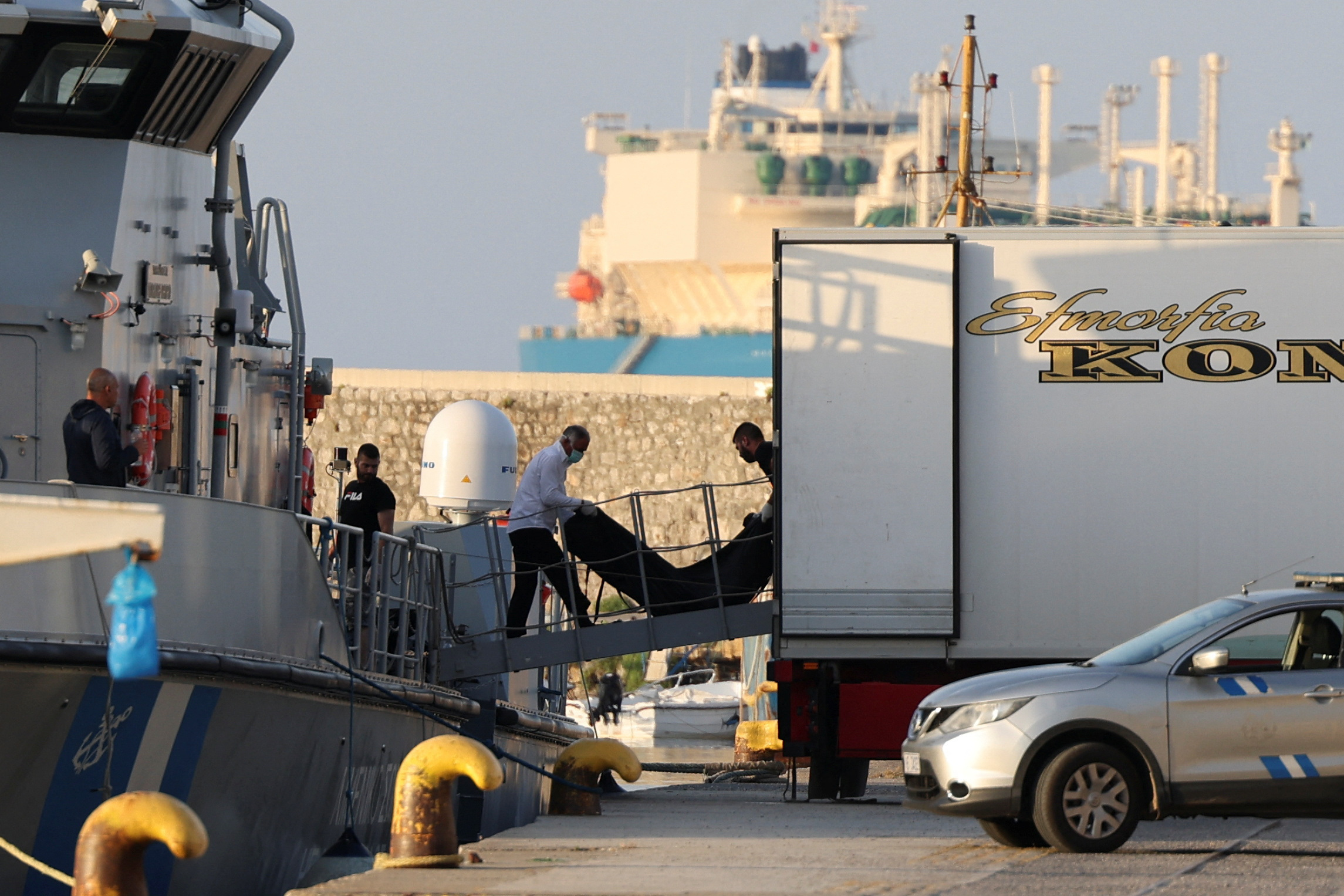 Body bags carrying migrants who drowned at sea in a shipwreck arrive in Greek port