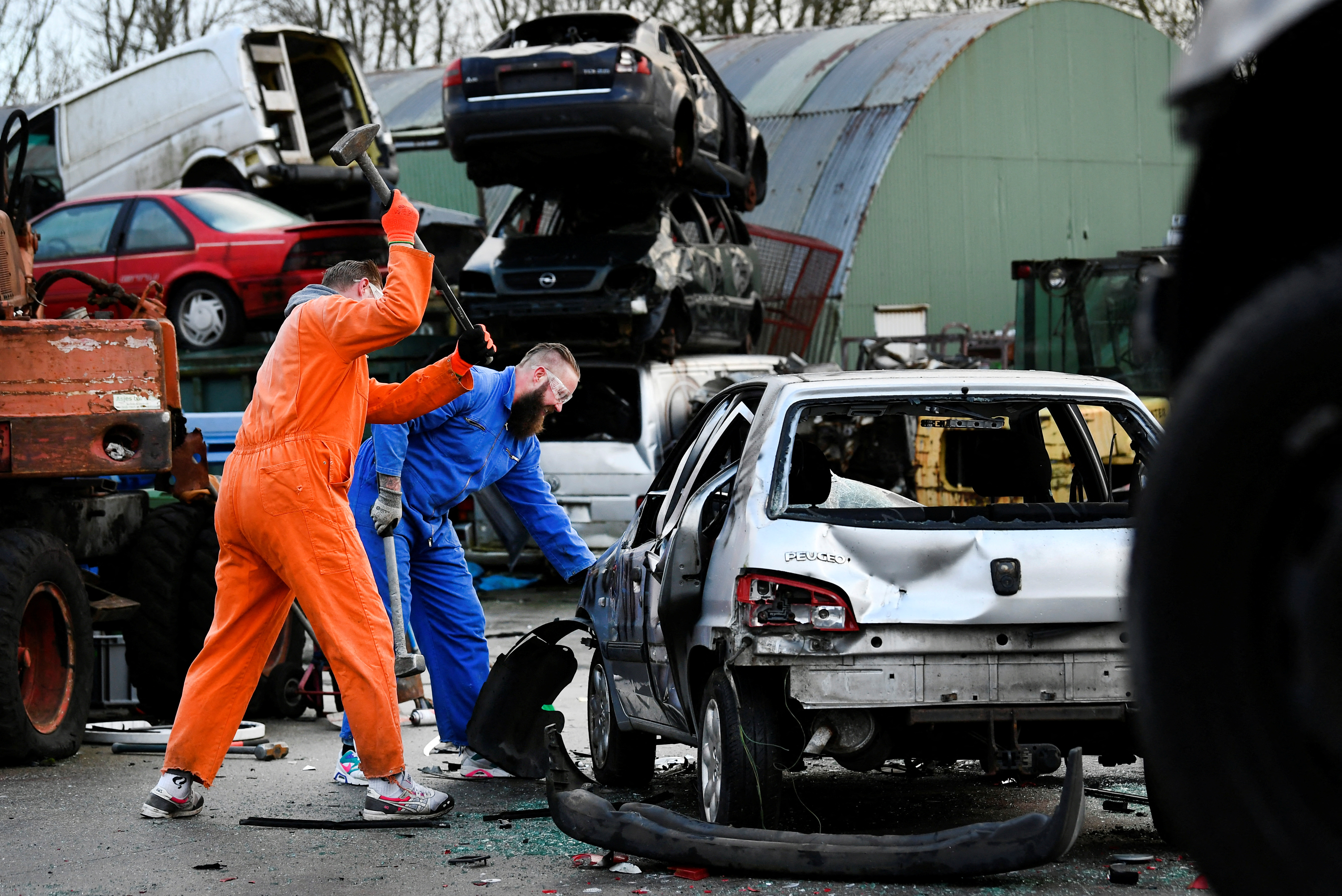 Twin brothers Steven and Brian Krijger use hammers to scrap a car to express their frustration as the Netherlands undergoes another lockdown