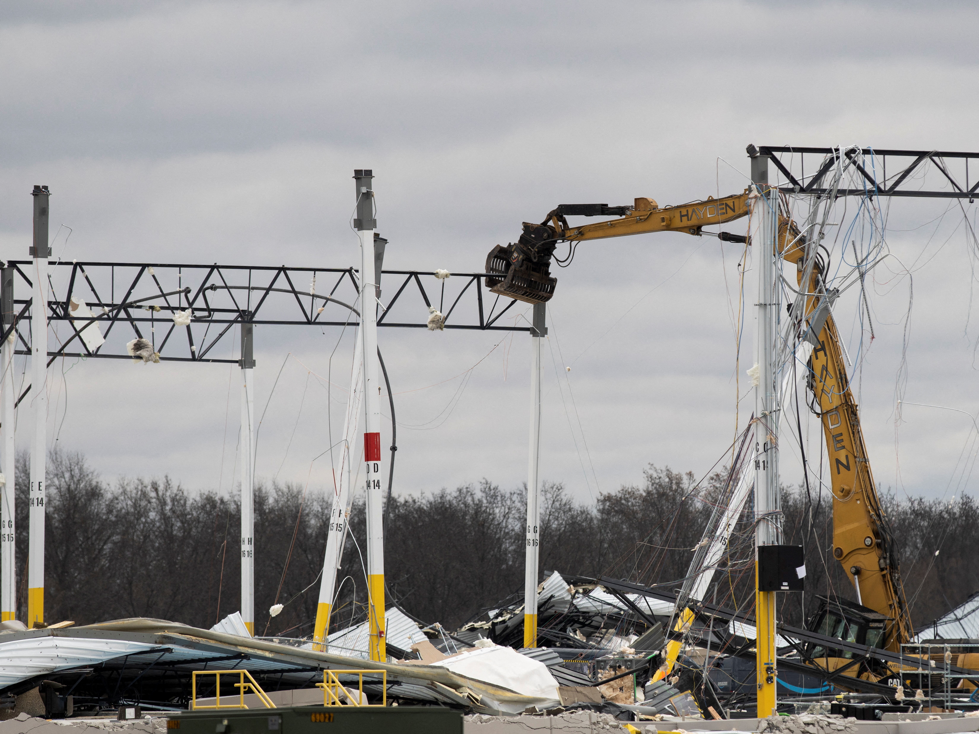 A crane takes down a beam at the site of a roof collapse at an Amazon distribution center after a tornado hits in Edwardsville, Illinois, U.S. December 11, 2021.  REUTERS/Lawrence Bryant