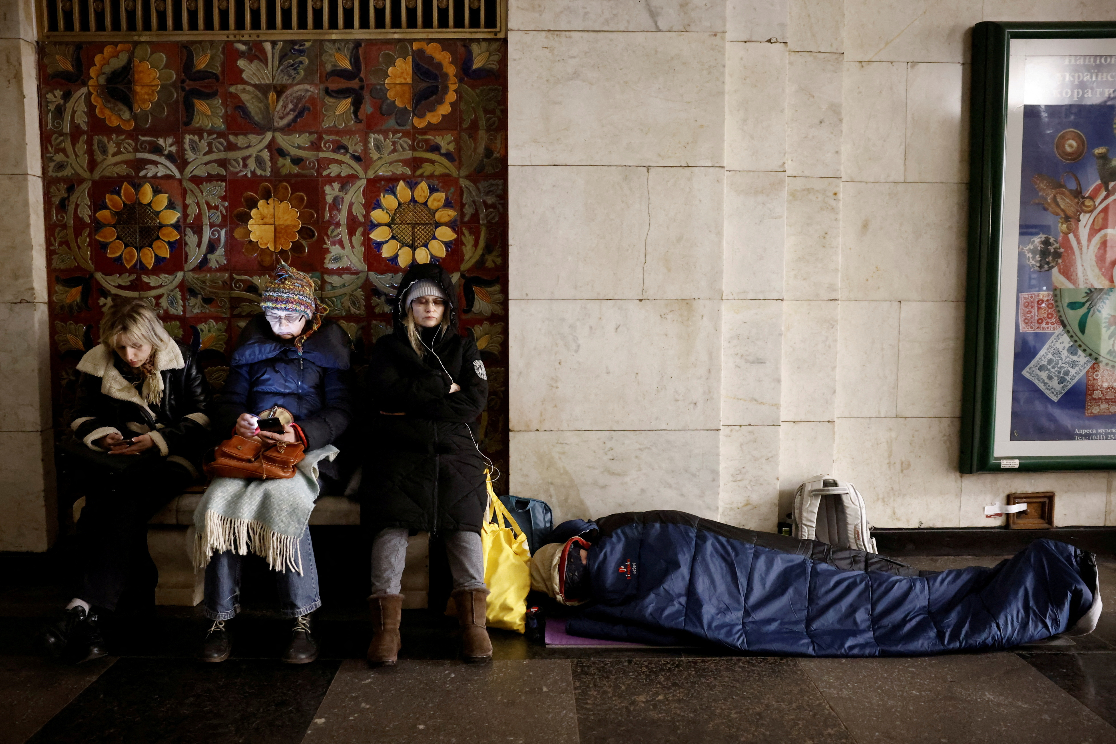 People take shelter in a metro station during a Russian missile strike, in Kyiv