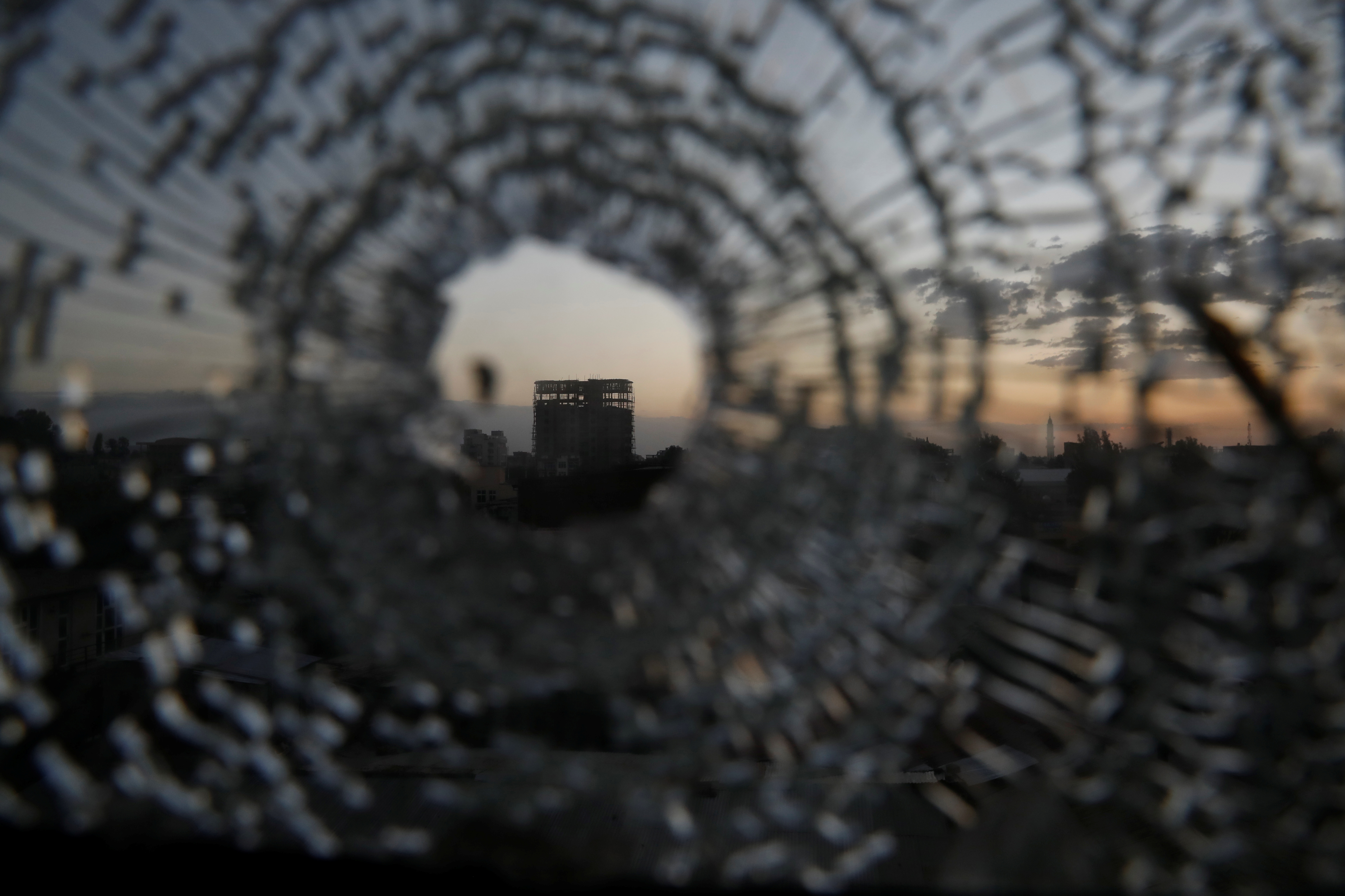 Building is seen through a bullet hole in a window of the Africa Hotel in the town of Shire, Tigray region