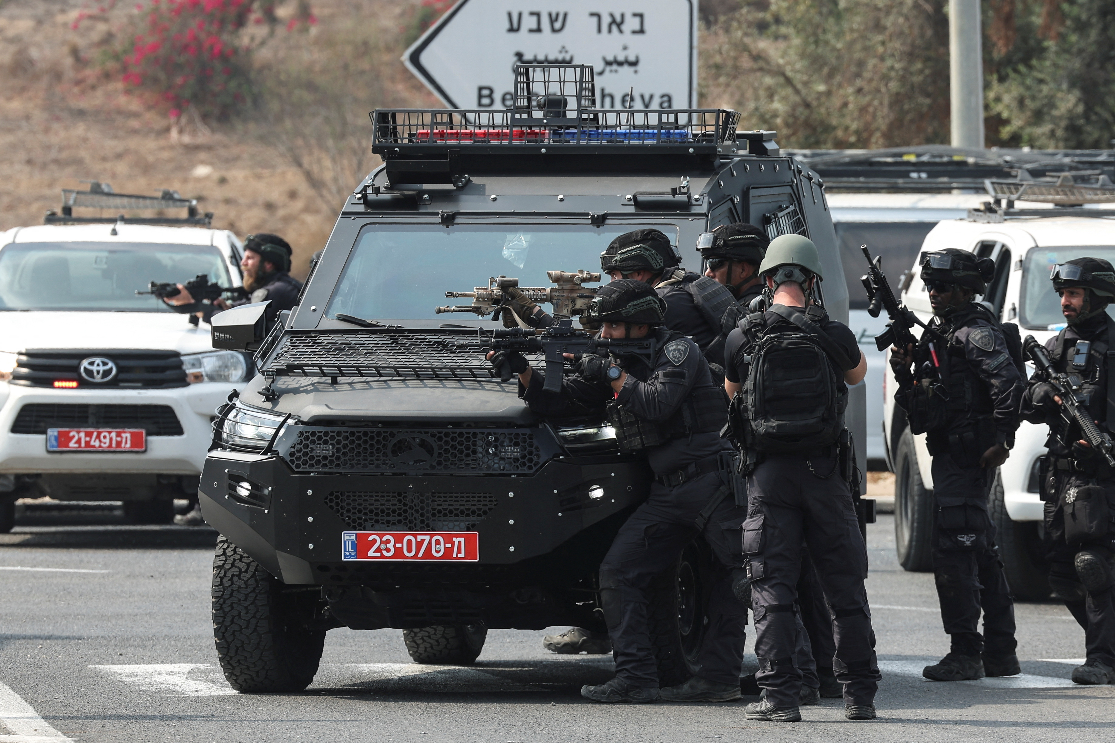 Israeli security stand in position on a road following a mass infiltration by Hamas gunmen from the Gaza Strip, near Sderot