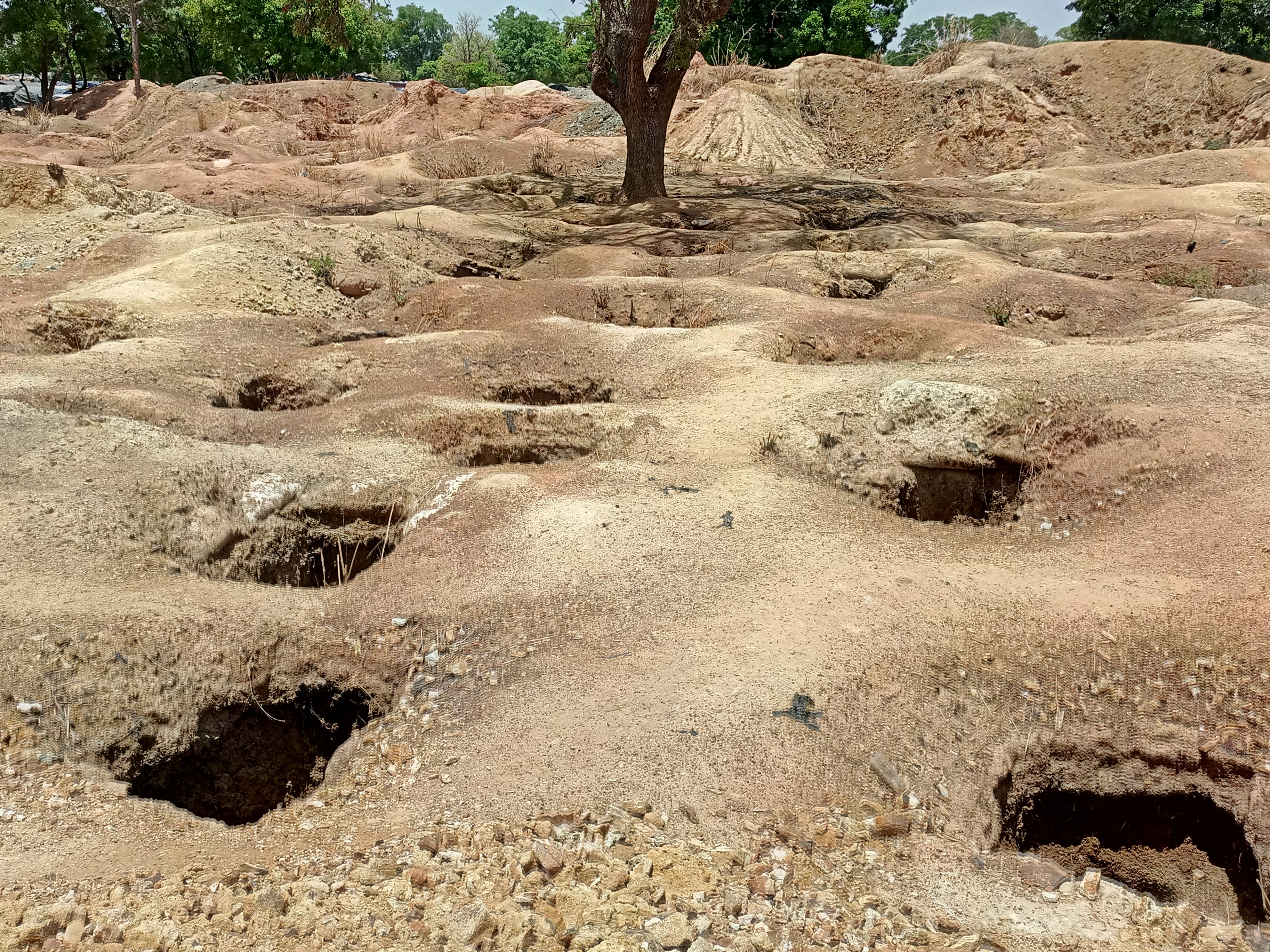 Artisanal gold mining pits are seen at a mining site near Dano