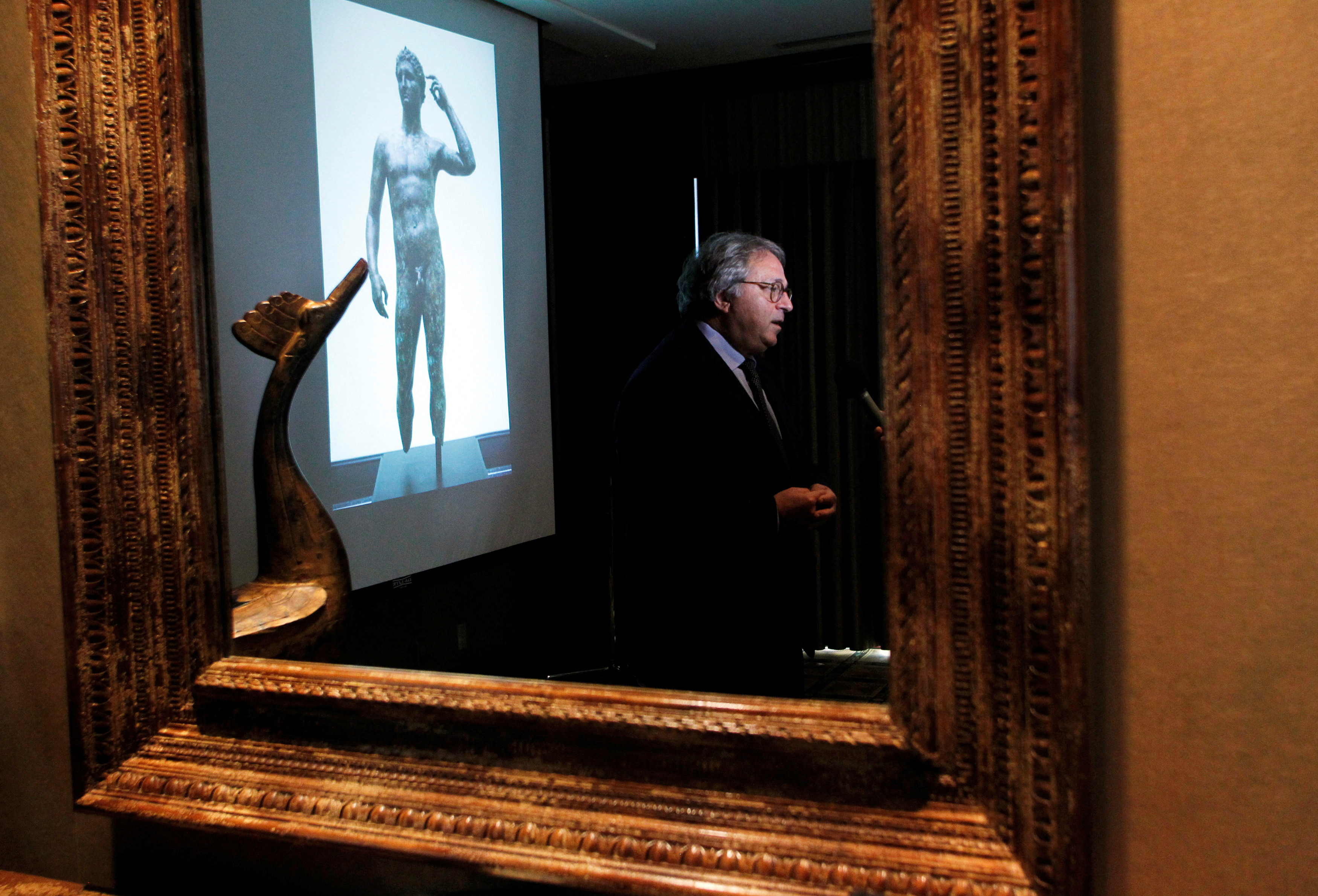 Gian Mario Spacca is seen reflected in a mirror while being interviewed in Los Angeles