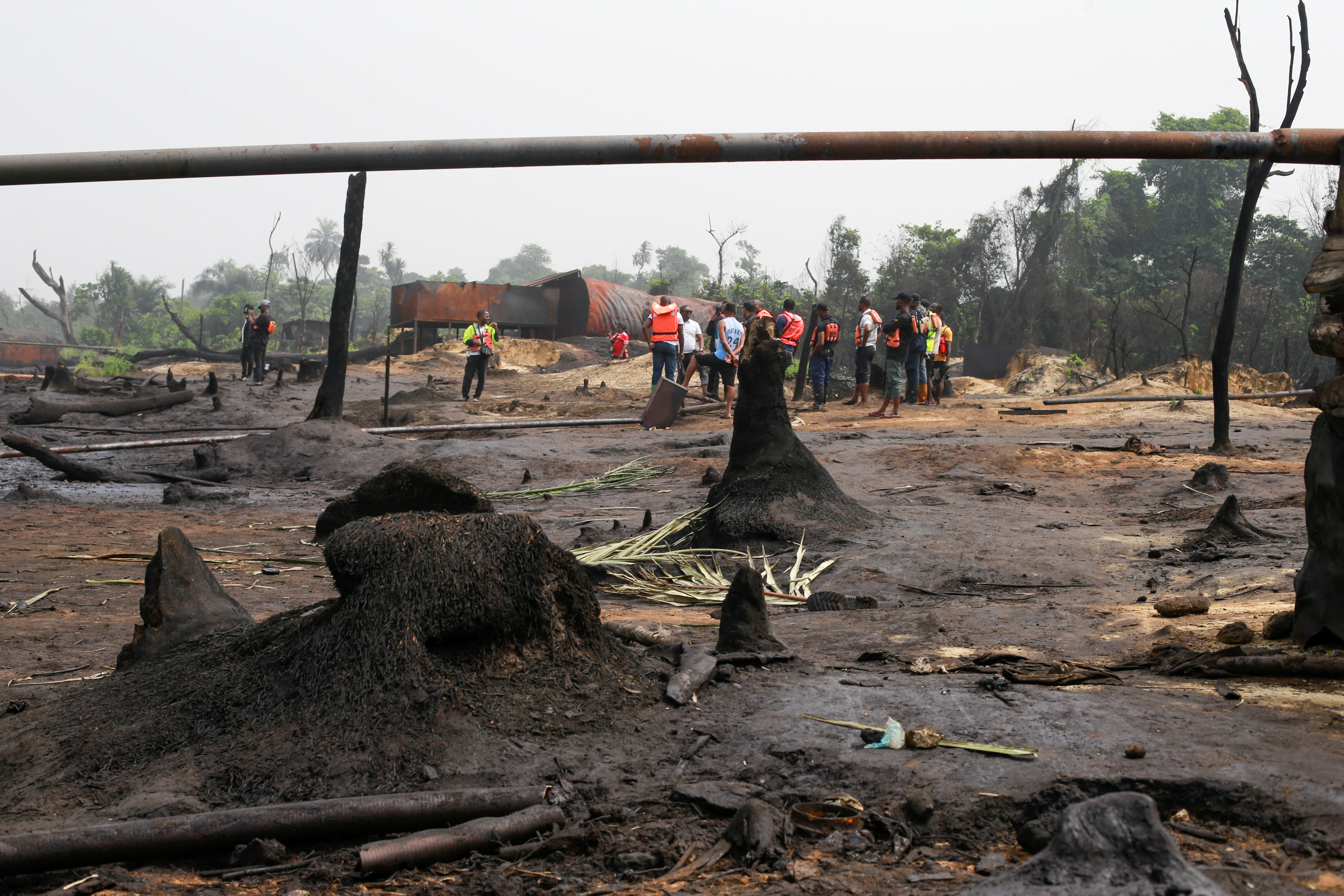 Members of the task force on illegal crude oil bunkering and artisanal refinery gather during the destruction of Bakana ii illegal artisanal camp in Okrika