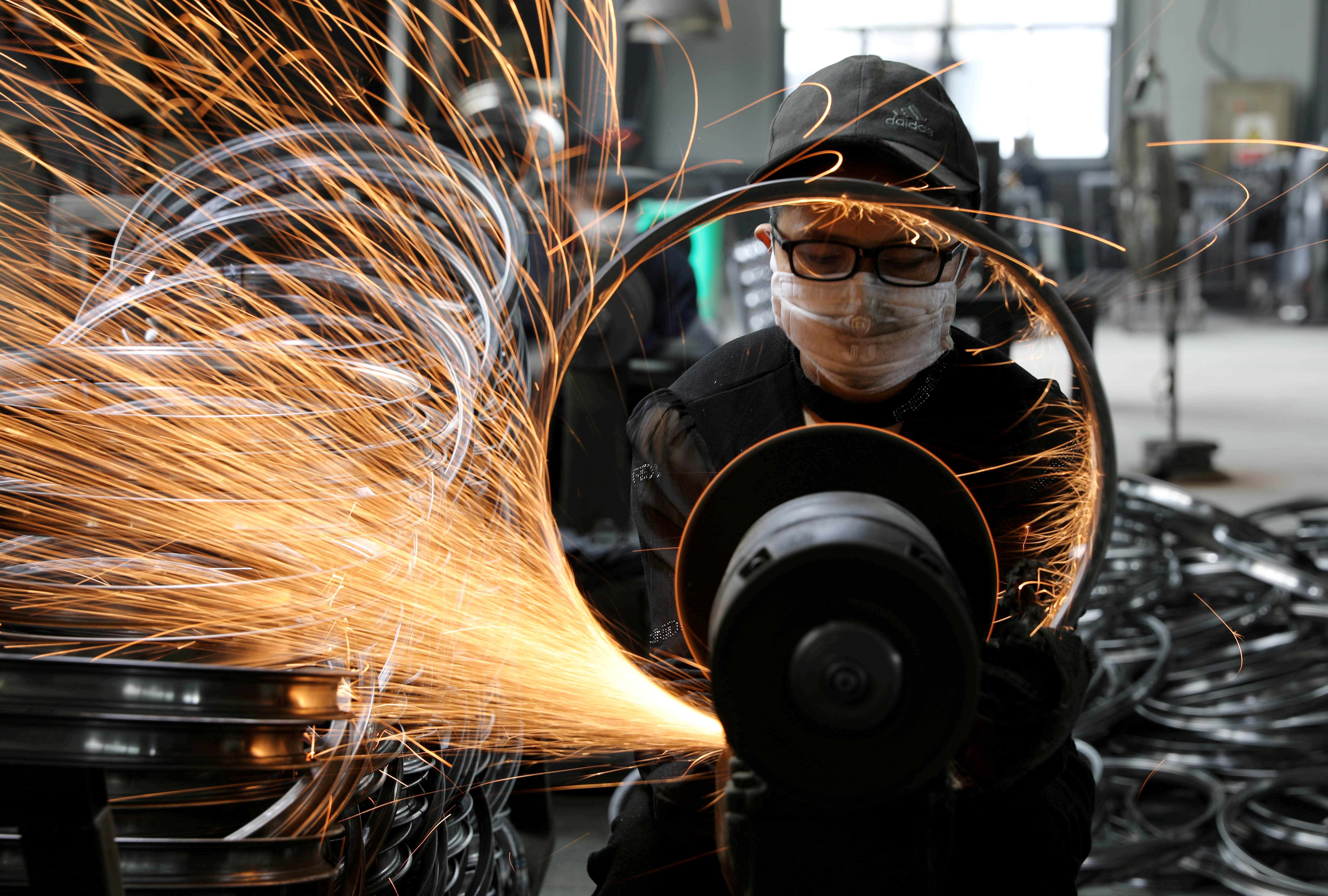 A worker welds a steel rim for a bicycle at a sports equipment factory in Hangzhou, Zhejiang province.