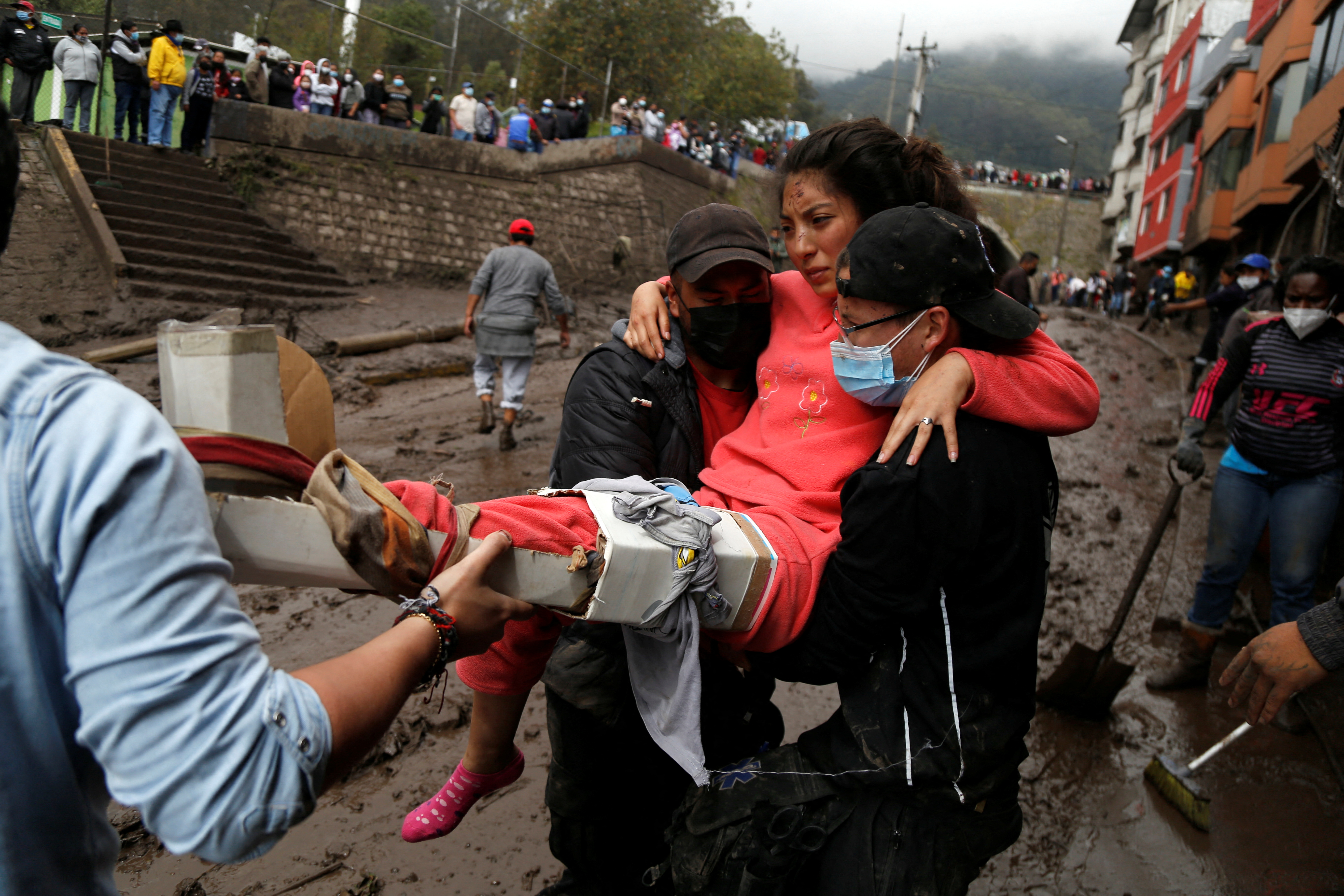 Firefighter rescue crews searching homes and streets covered by mud in Quito
