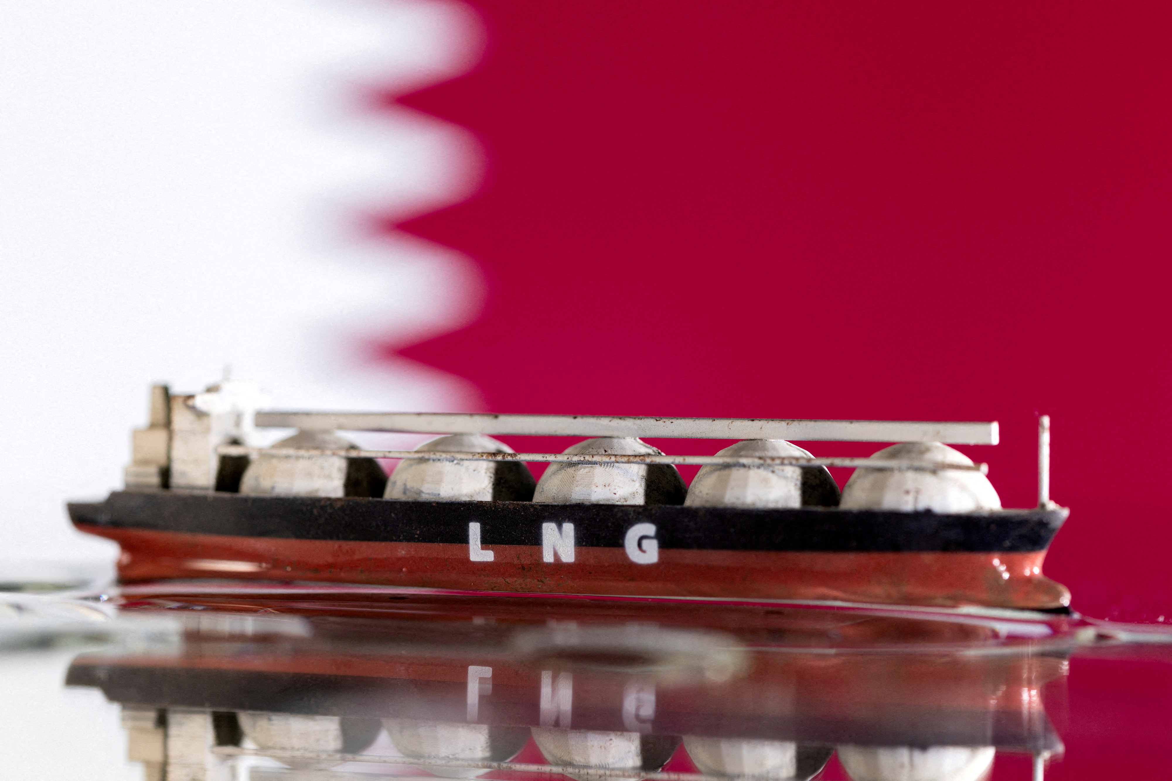 Illustration shows model of LNG tanker and Qatar's flag