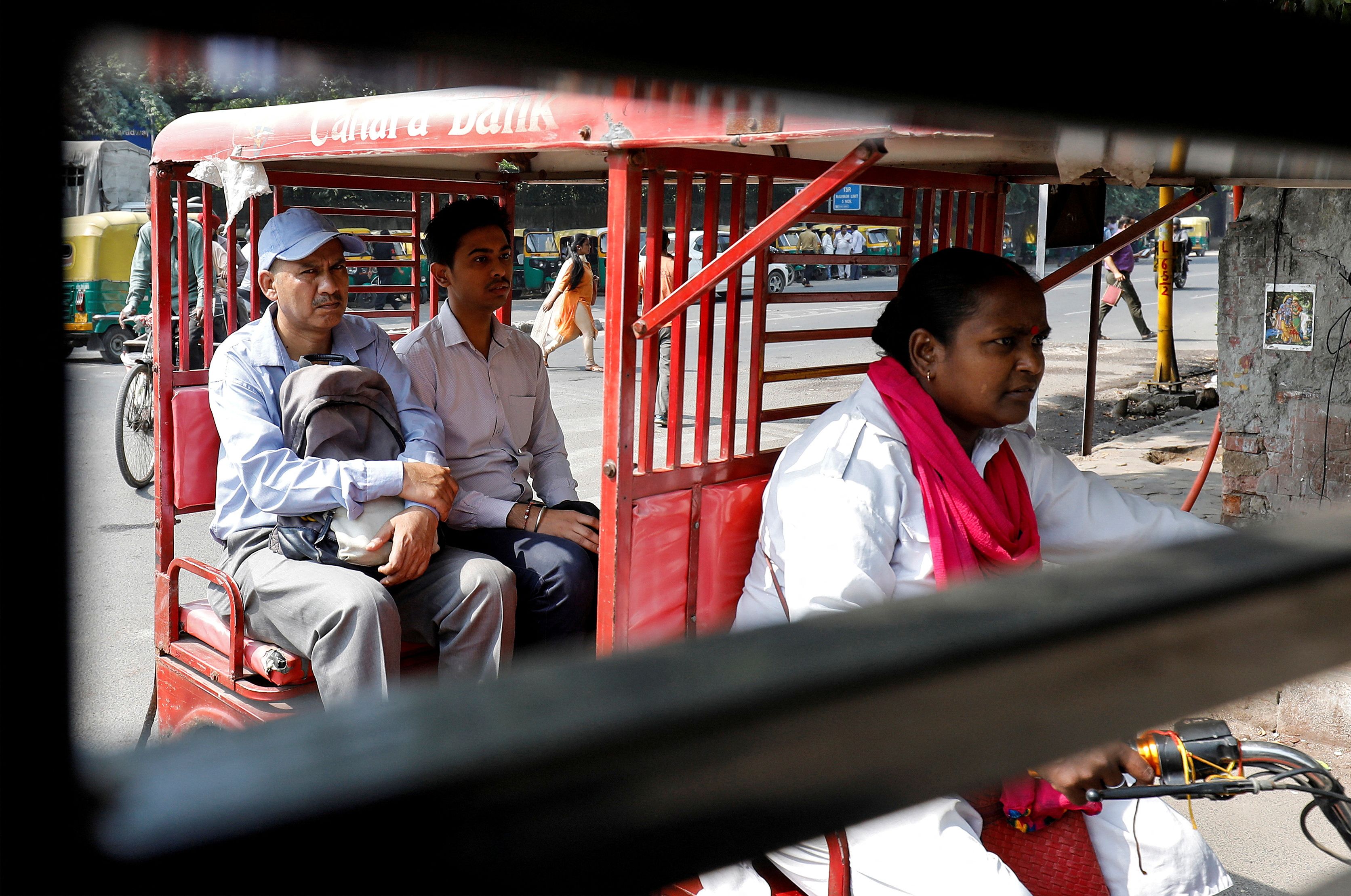 Binota Gayen rides an electric rickshaw carrying passengers in New Delhi