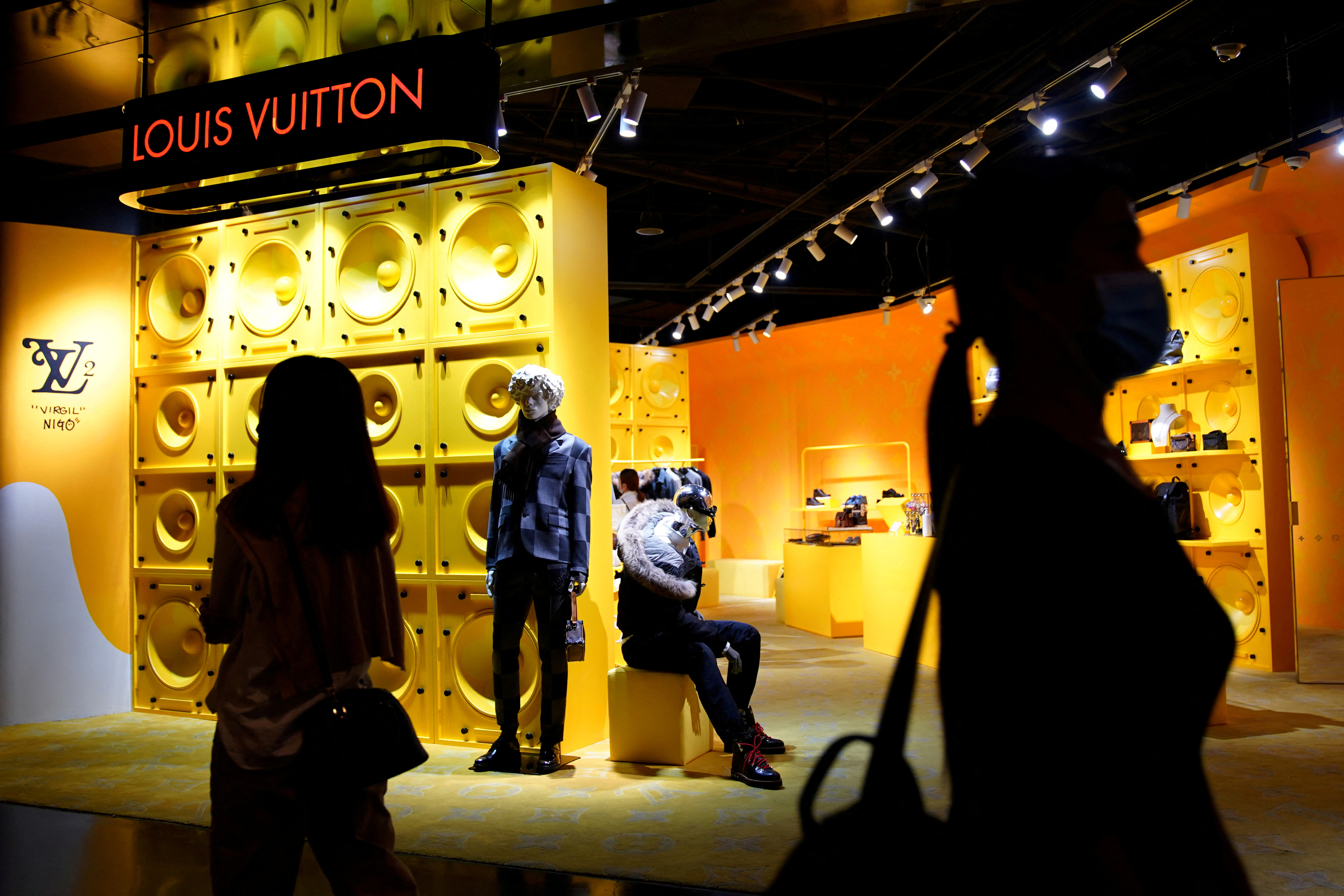 Customers walk past a store of French luxury brand Louis Vuitton inside a shopping mall in Beijing