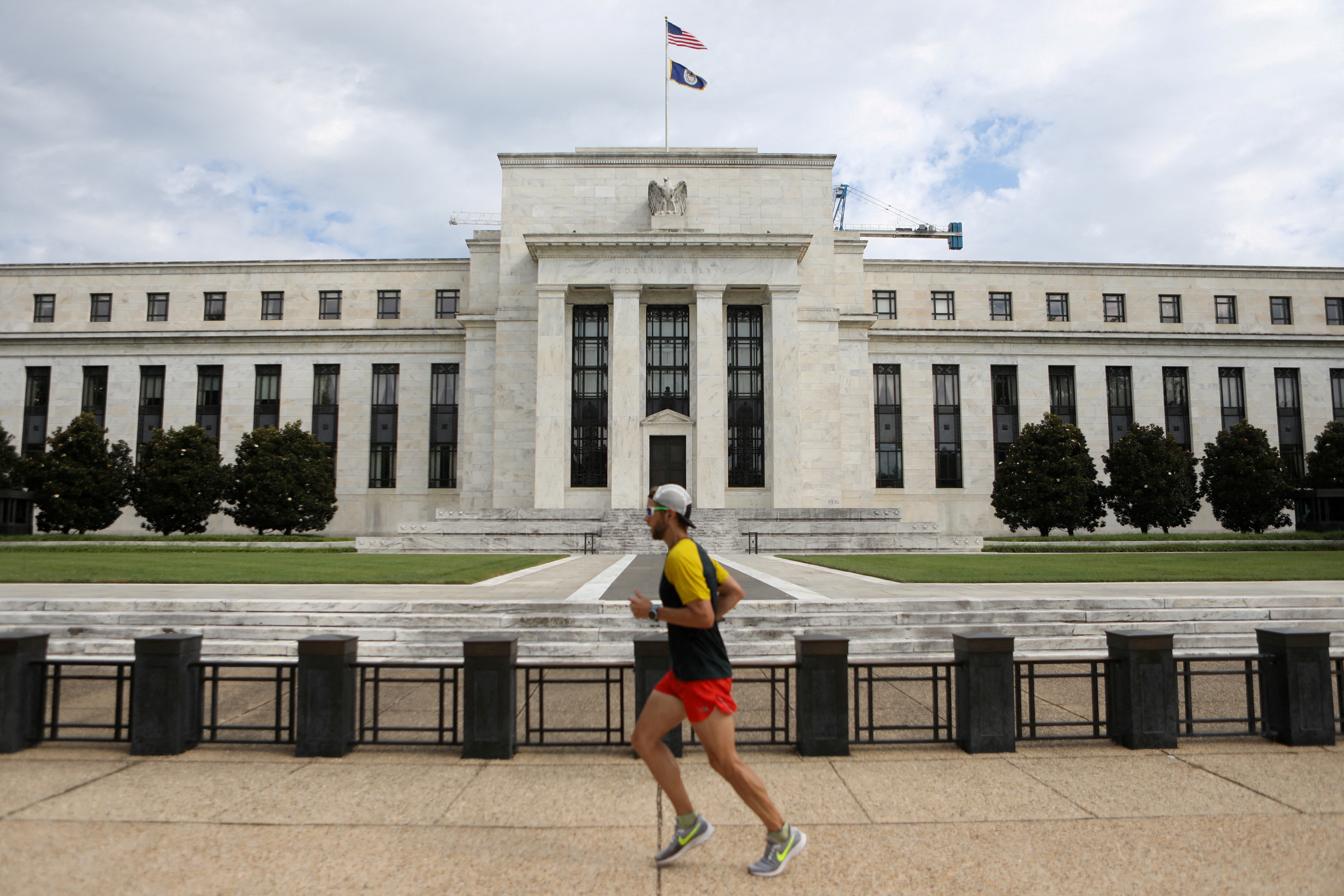 A jogger runs past the Federal Reserve building in Washington, DC
