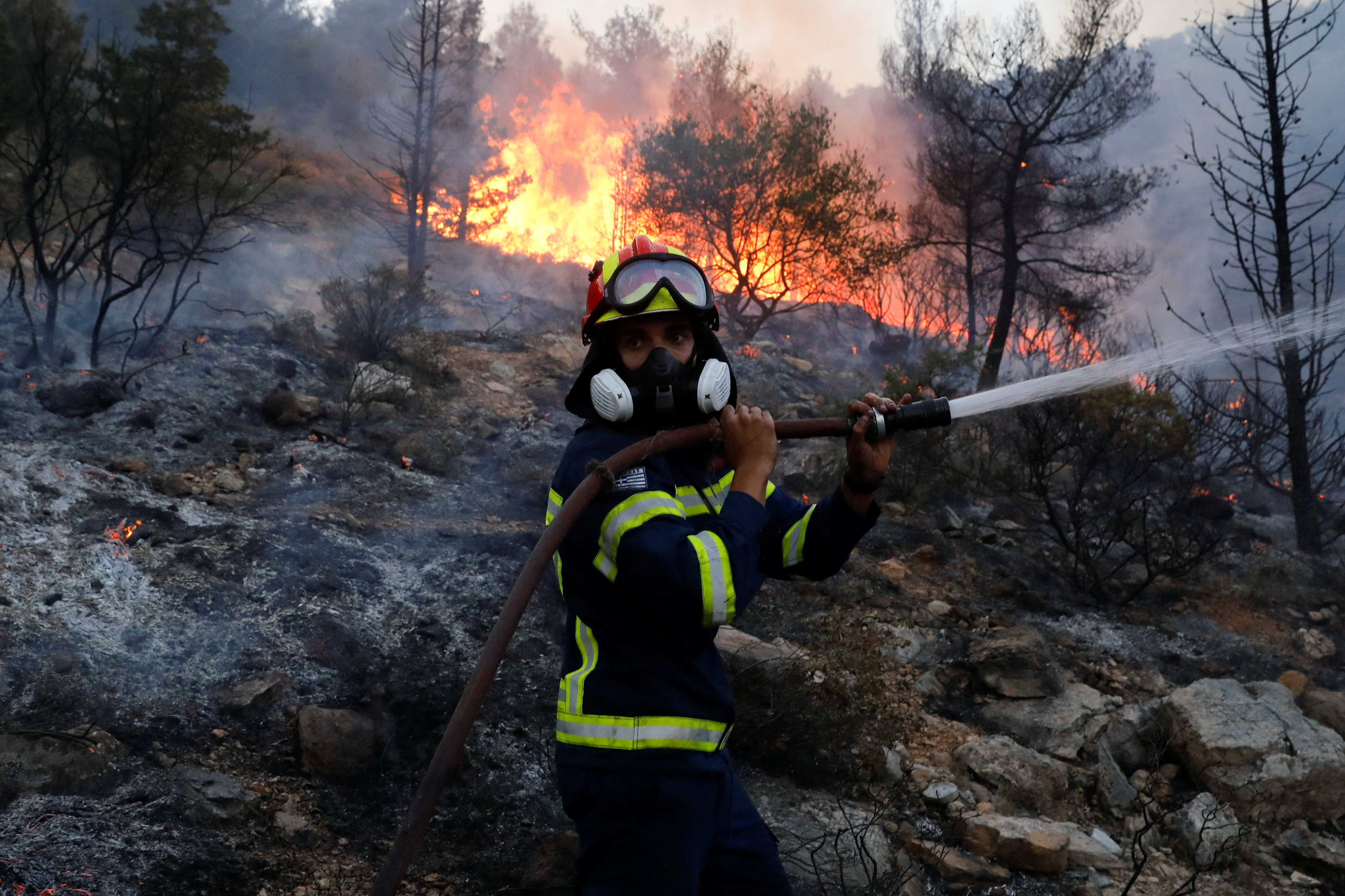A firefighter tries to extinguish a wildfire near Vari, south of Athens