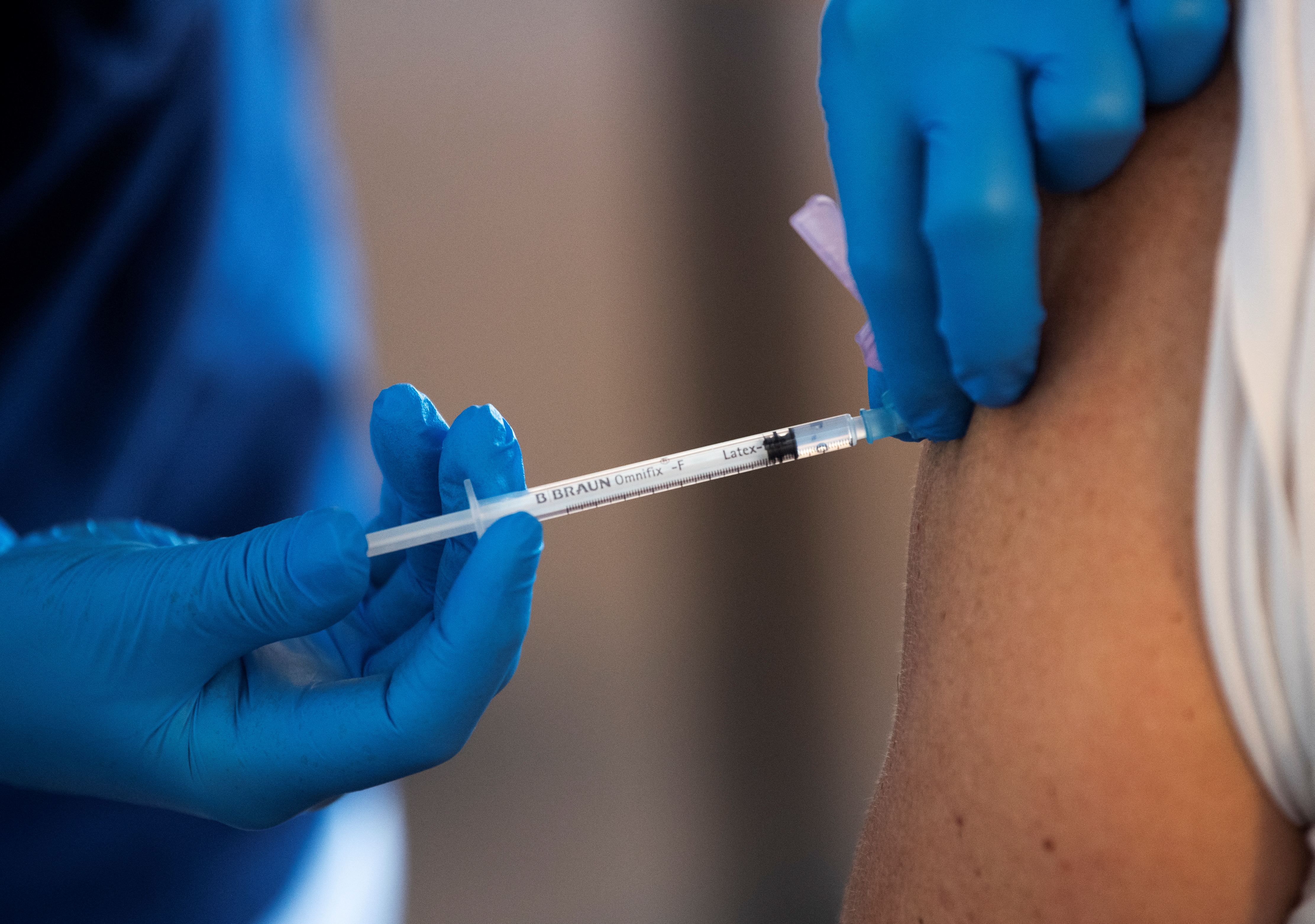 A health worker vaccinates an elderly person with Pfizer's COVID-19 vaccine at a temporary vaccination clinic in a church in Sollentuna, north of Stockholm, Sweden March 2, 2021. Fredrik Sandberg/TT News Agency/via REUTERS