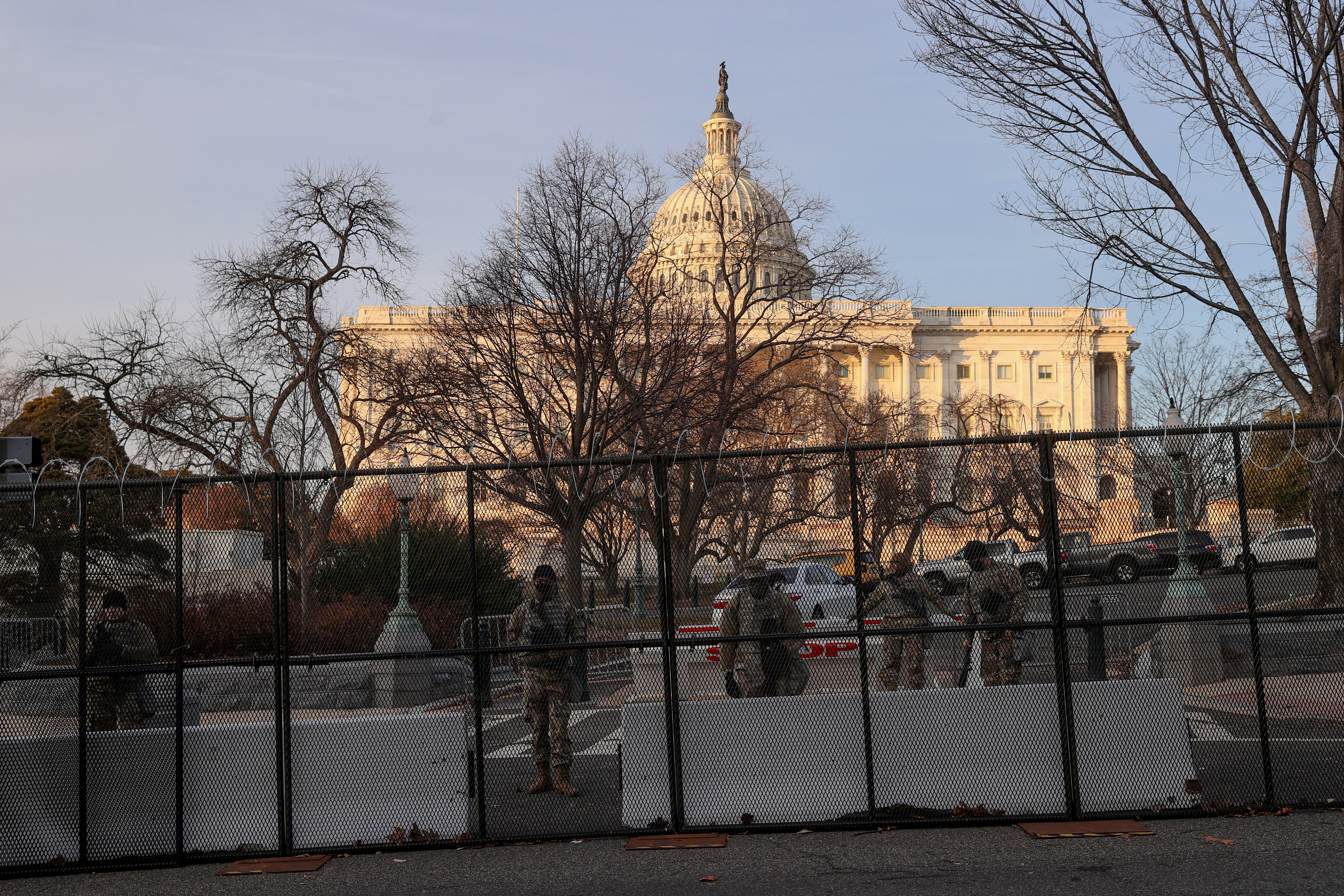 Workers install razor wire atop the unscalable fence surrounding the U.S. Capitol in Washington