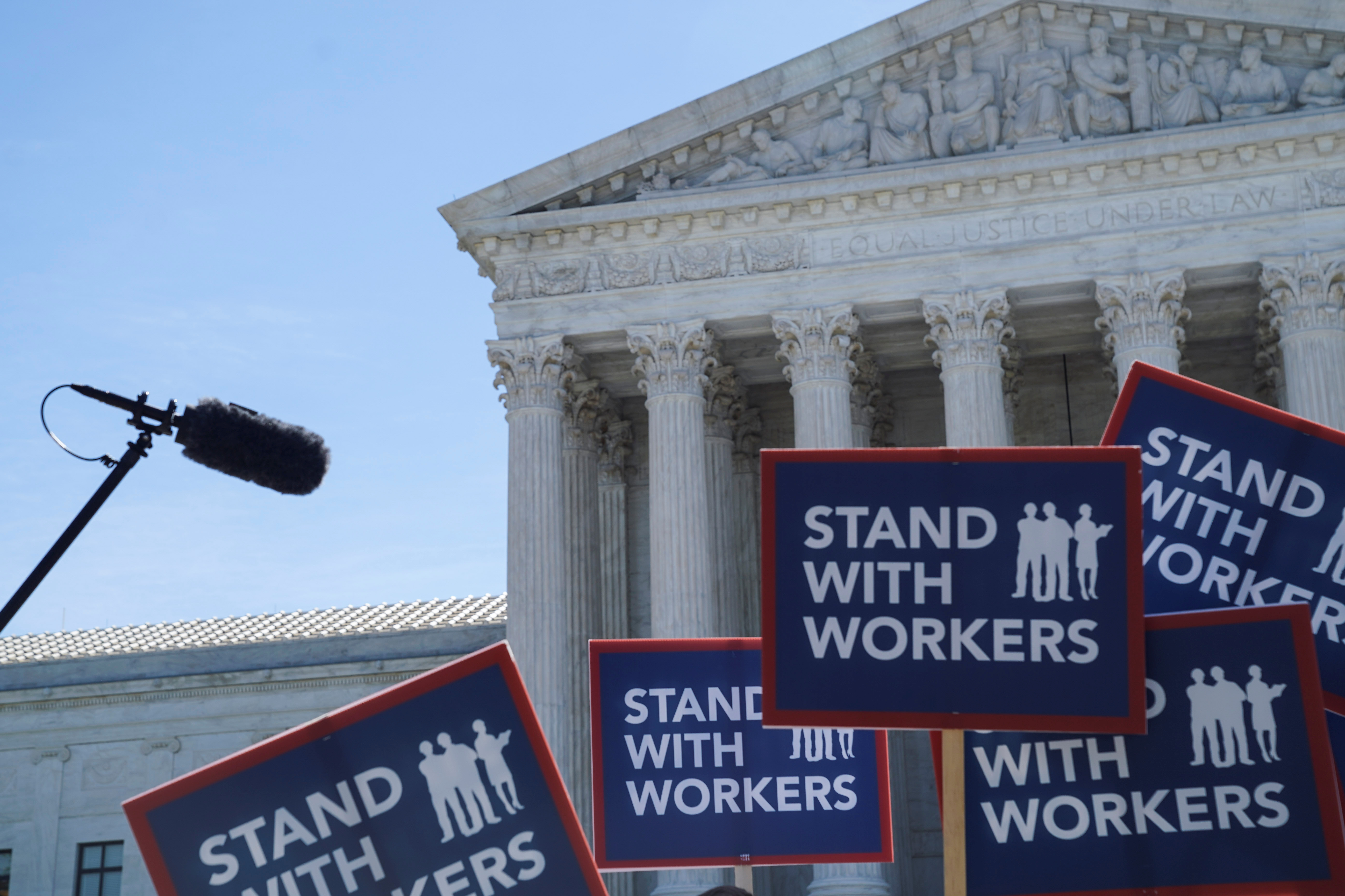 People hold signs outside the U.S. Supreme Court, waiting for the Janus v. American Federation of State, County, and Municipal Employees case, June 25, 2018. REUTERS/Toya Sarno Jordan