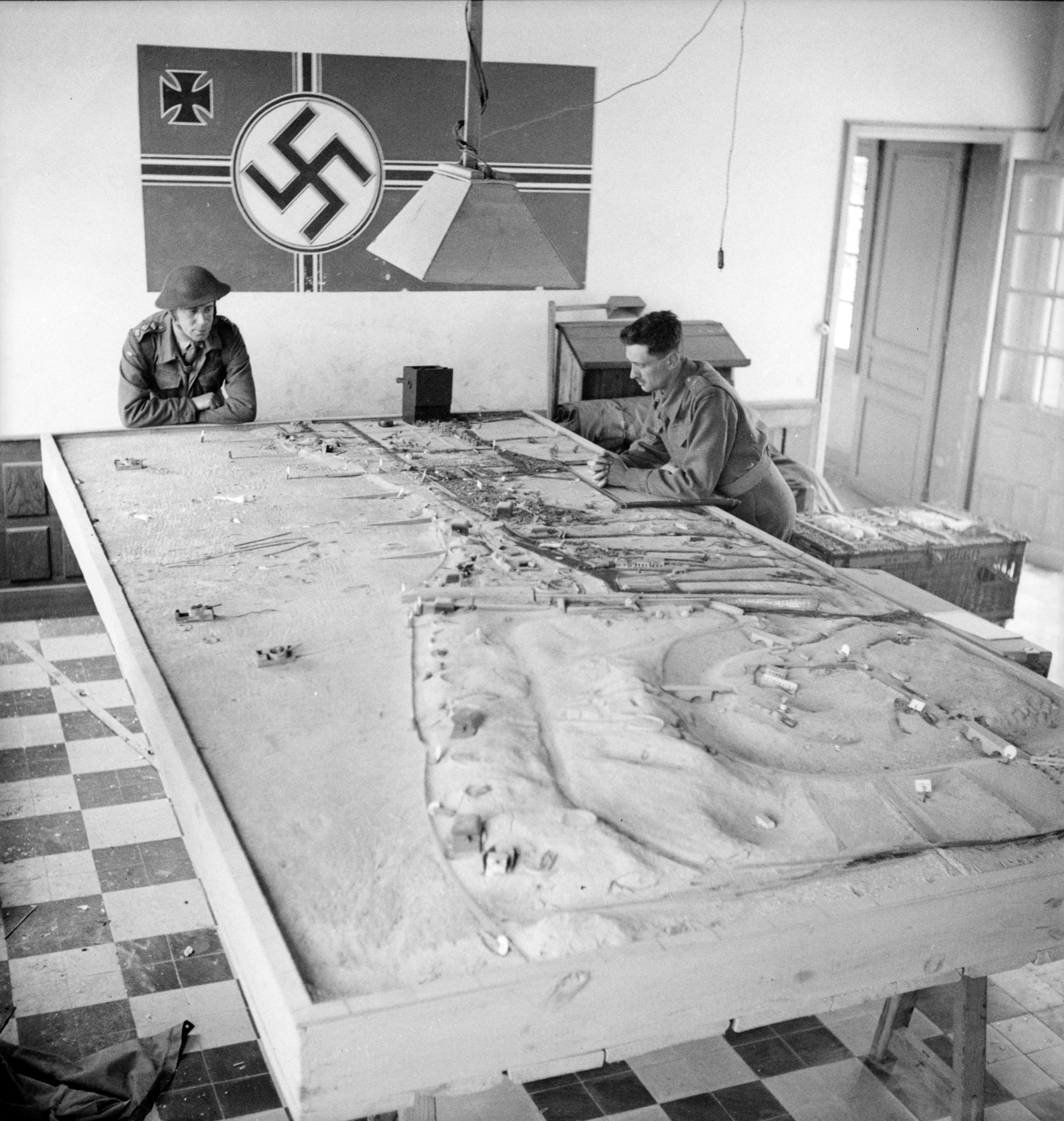 Canadian soldiers study a German plan of the beach during D-Day landing operations in Normandy