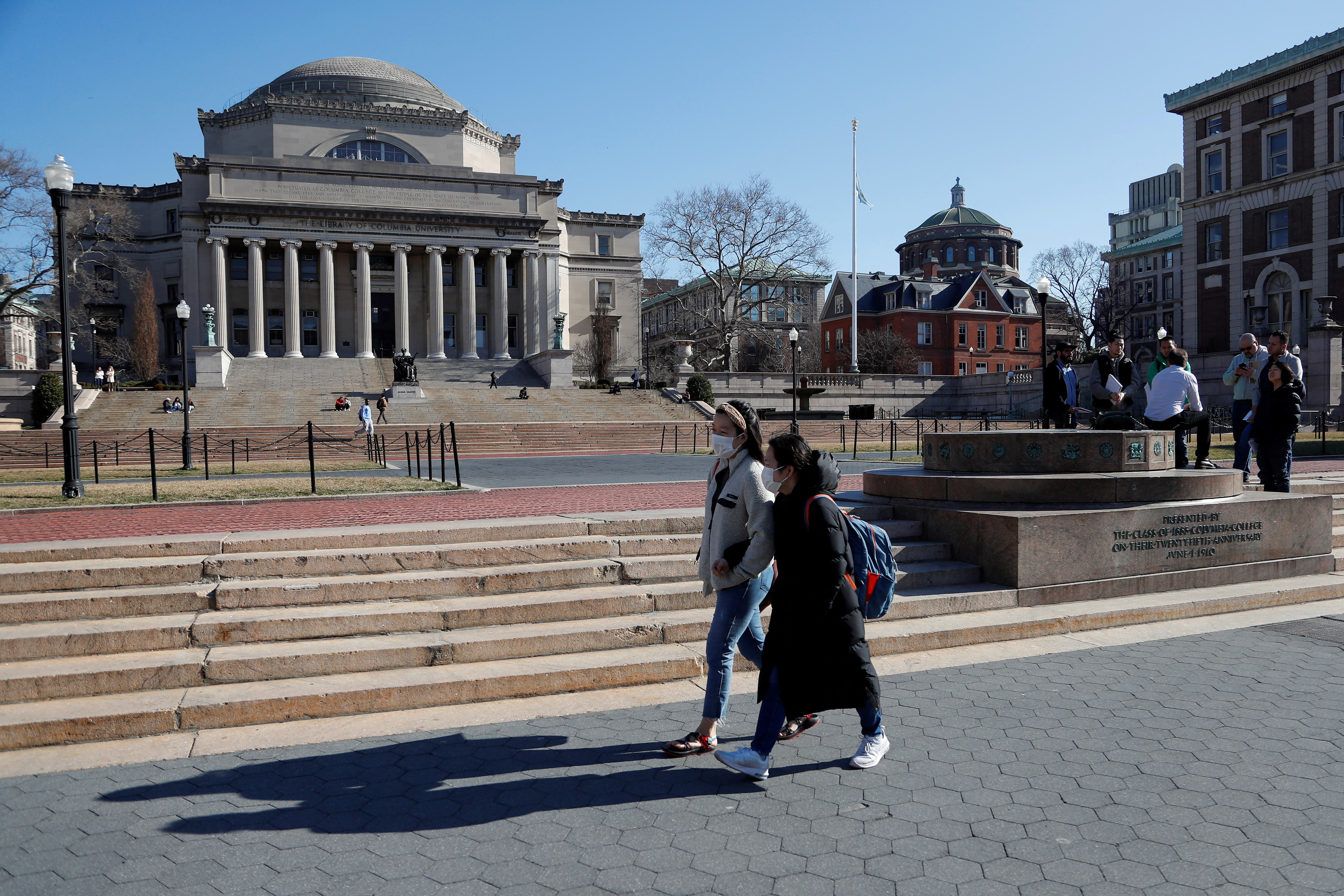 People with face masks walk at Columbia University in New York City, where classes on Monday and Tuesday were suspended because someone on the campus was under quarantine from exposure to the coronavirus