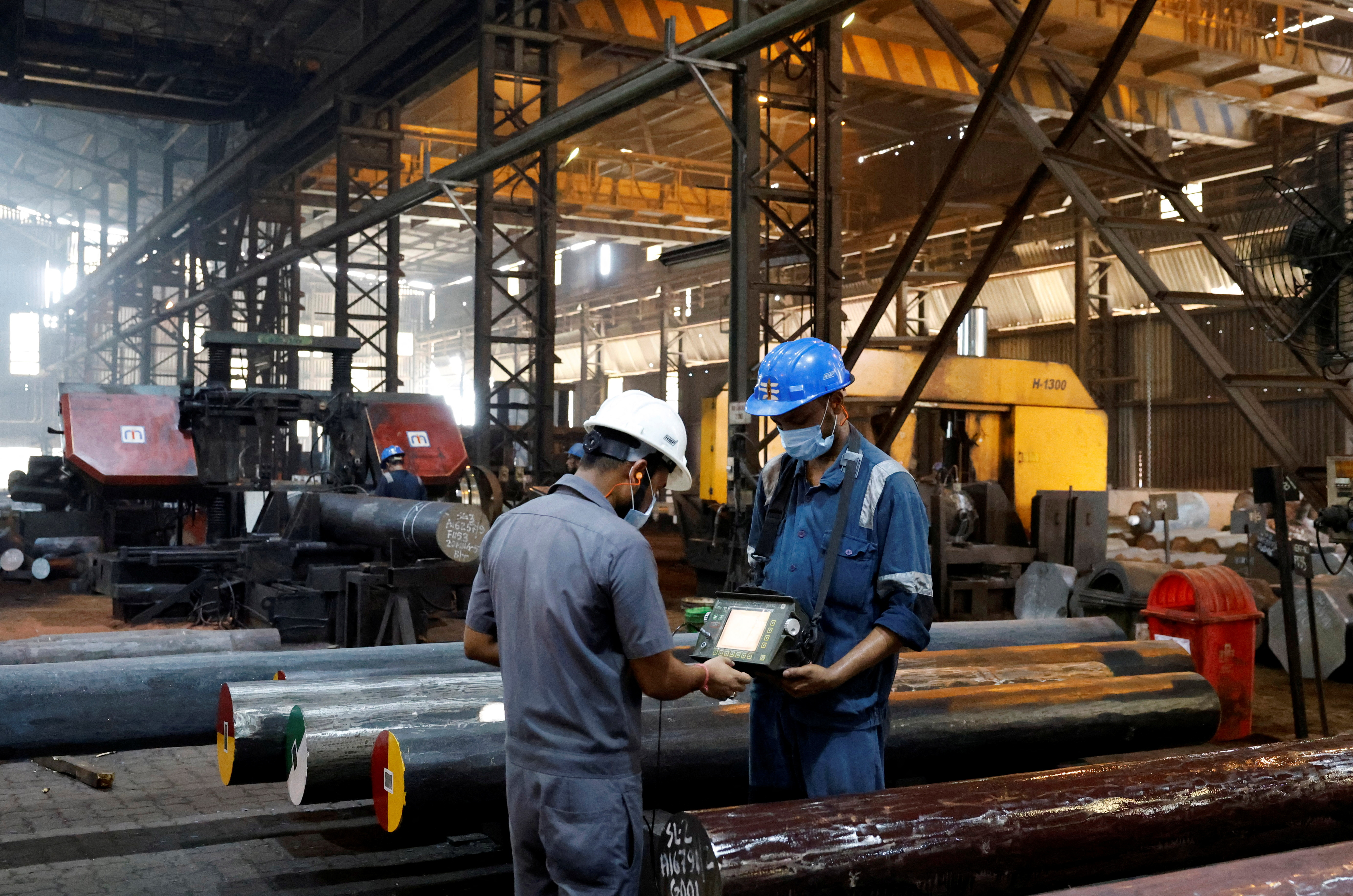 Employees conduct a quality check of ultrasonic soundness of the forged bars on a machine inside the ArcVac ForgeCast factory, in Hooghly district