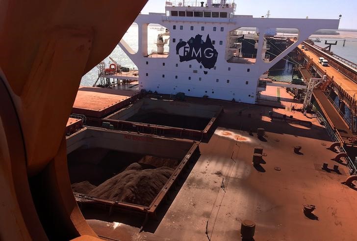 The logo of Australia's Fortescue Metals Group can be seen on a bulk carrier as it is loaded with iron ore at the coastal town of Port Hedland in Western Australia