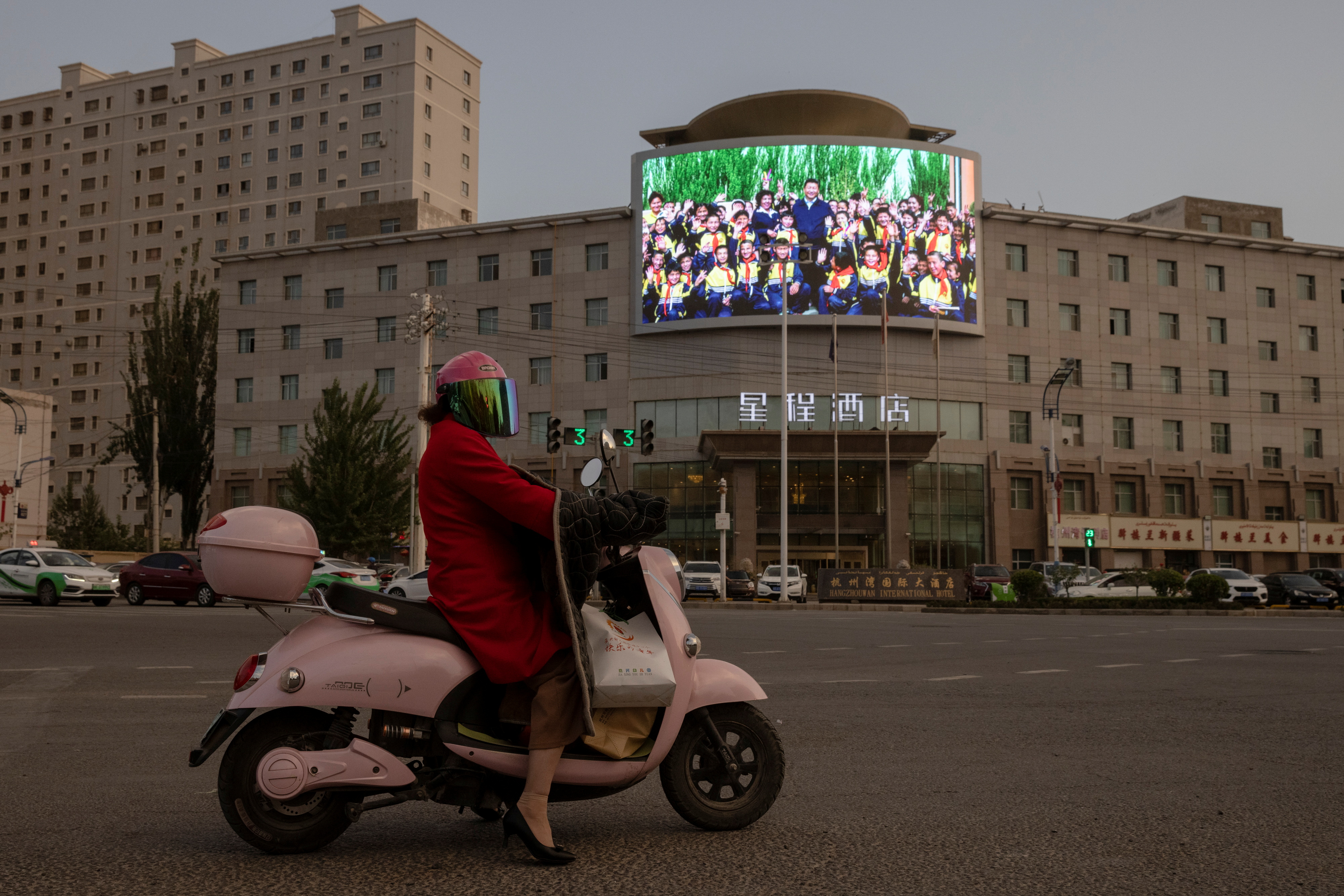 A screen shows a picture of Chinese President Xi Jinping at a traffic junction in Hotan, Xinjiang Uyghur Autonomous Region