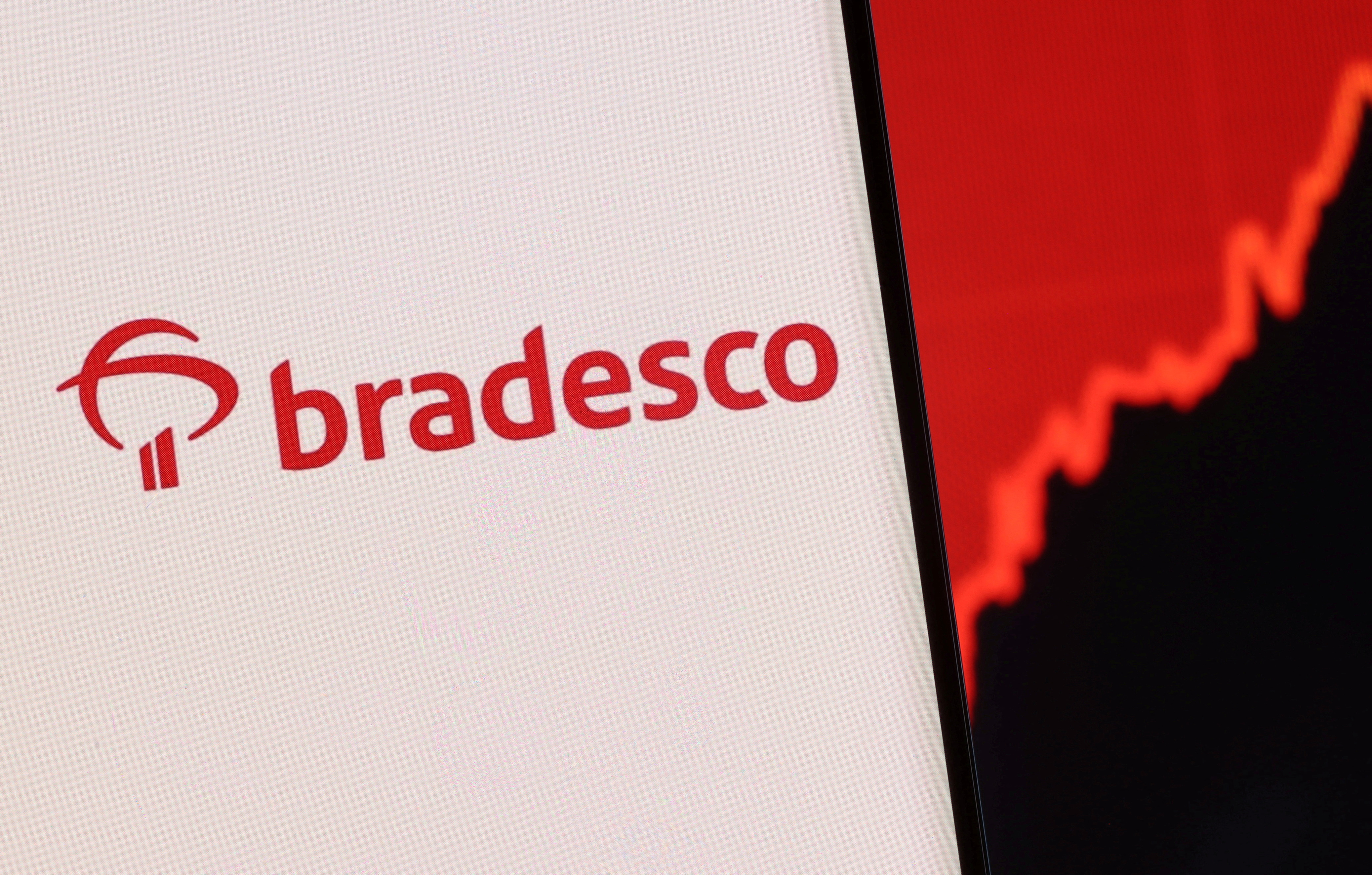 Illustration shows a smartphone with displayed Bradesco logo and stock graph