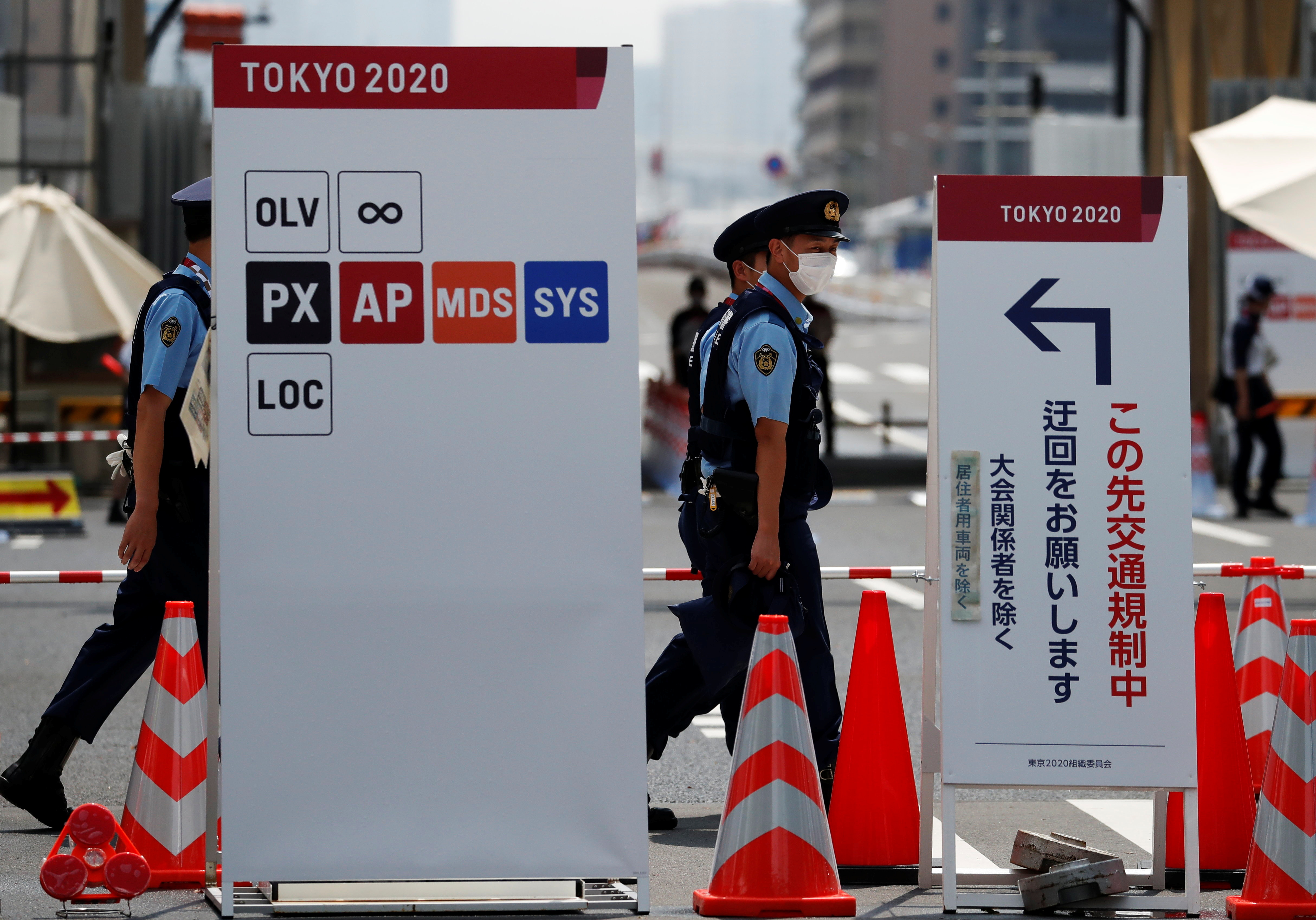 Police officers patrol at the entrance of the Athletes Village ahead of Tokyo 2020 Olympic Games in Tokyo