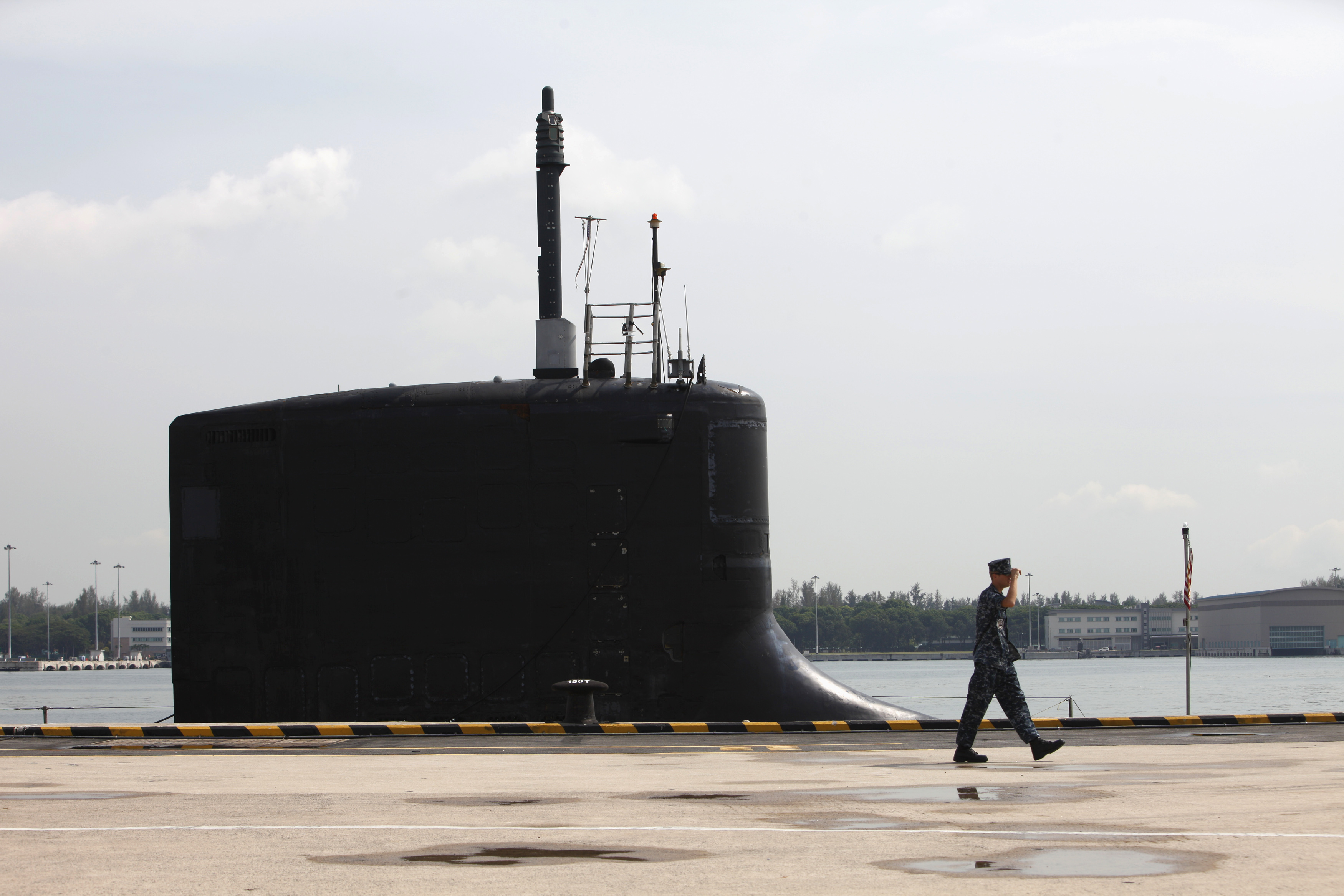 U.S. Navy personel walks past USS North Carolina submarine docked at Changi Naval Base in Singapore