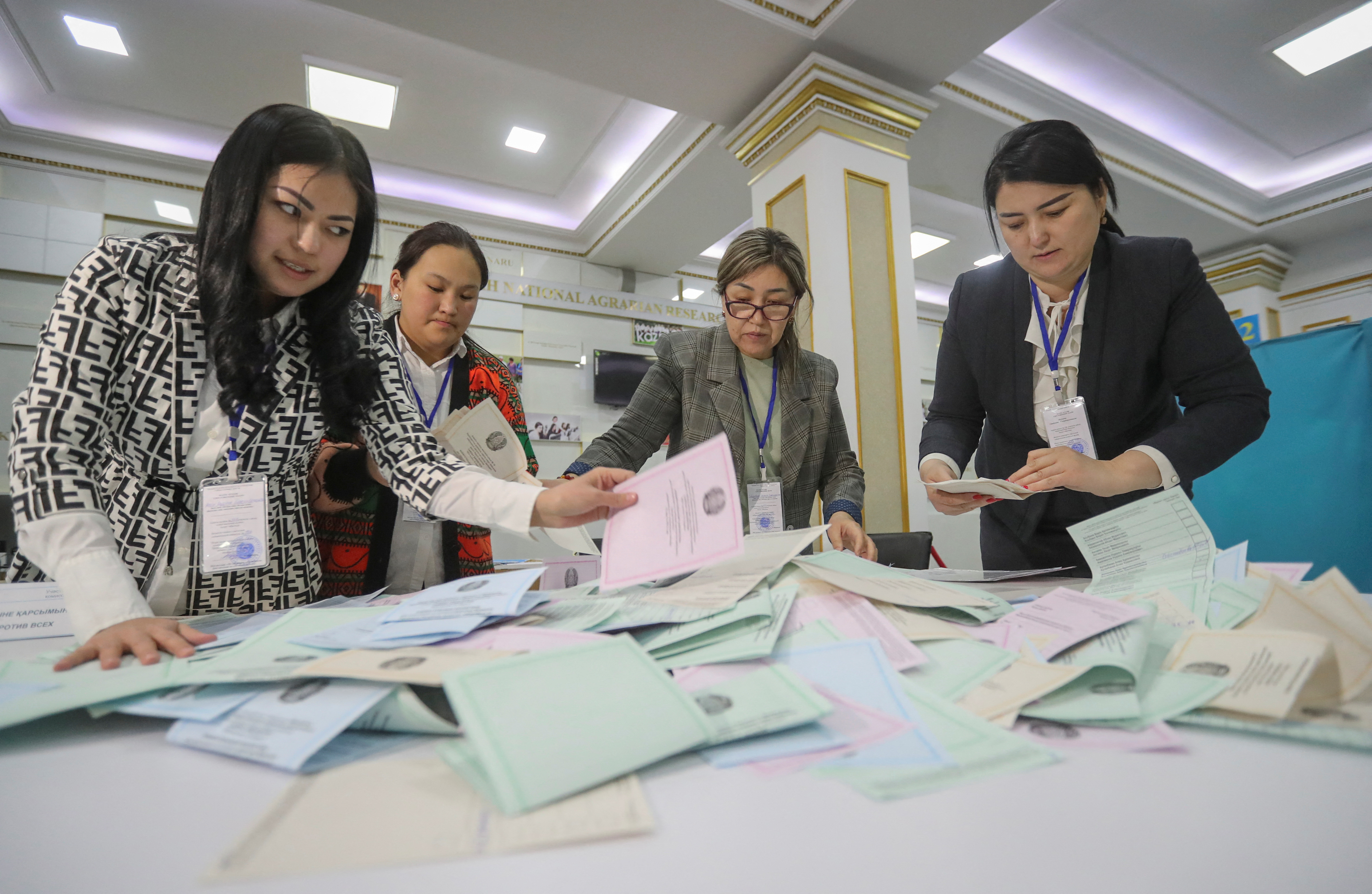 Members of a local election committee count ballots after polls closed during parliamentary election in Almaty