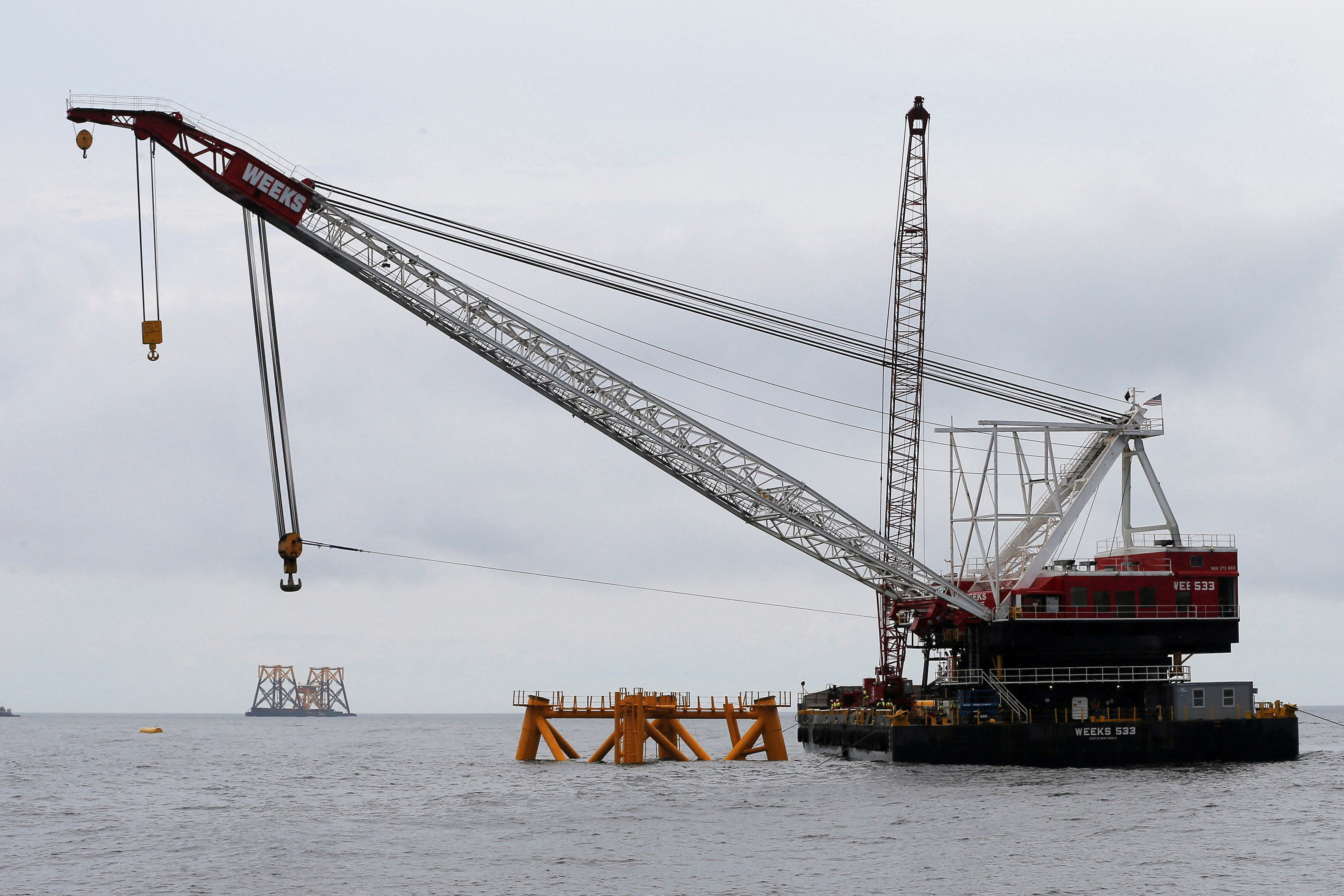 A construction barge and crane float next to the first jacket (C) installed to support a turbine for a wind farm in the waters of the Atlantic Ocean off Block Island, Rhode Island July 27, 2015. REUTERS/Brian Snyder/
